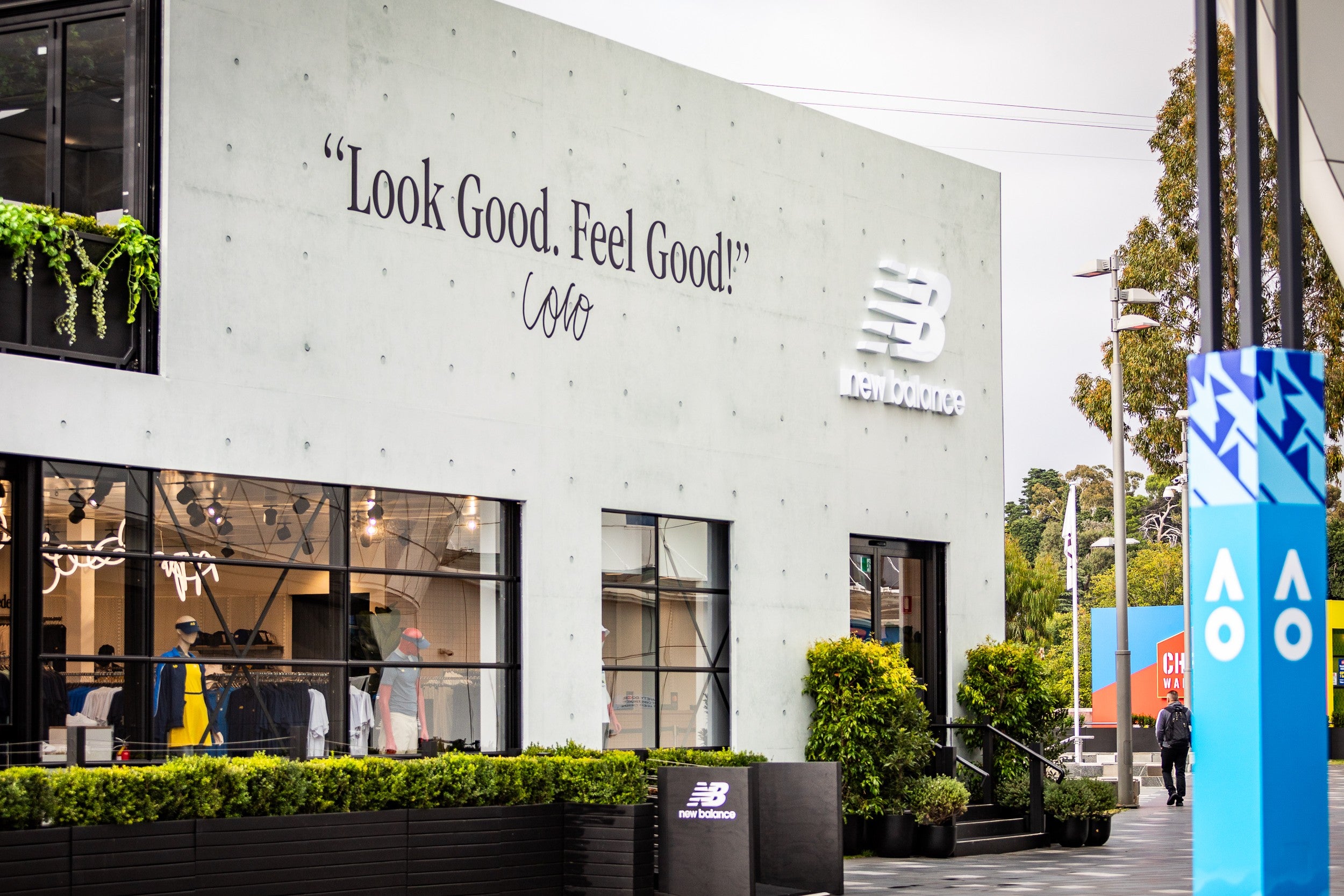 New Balance store marquee exterior with branding and promotional message on a building facade.