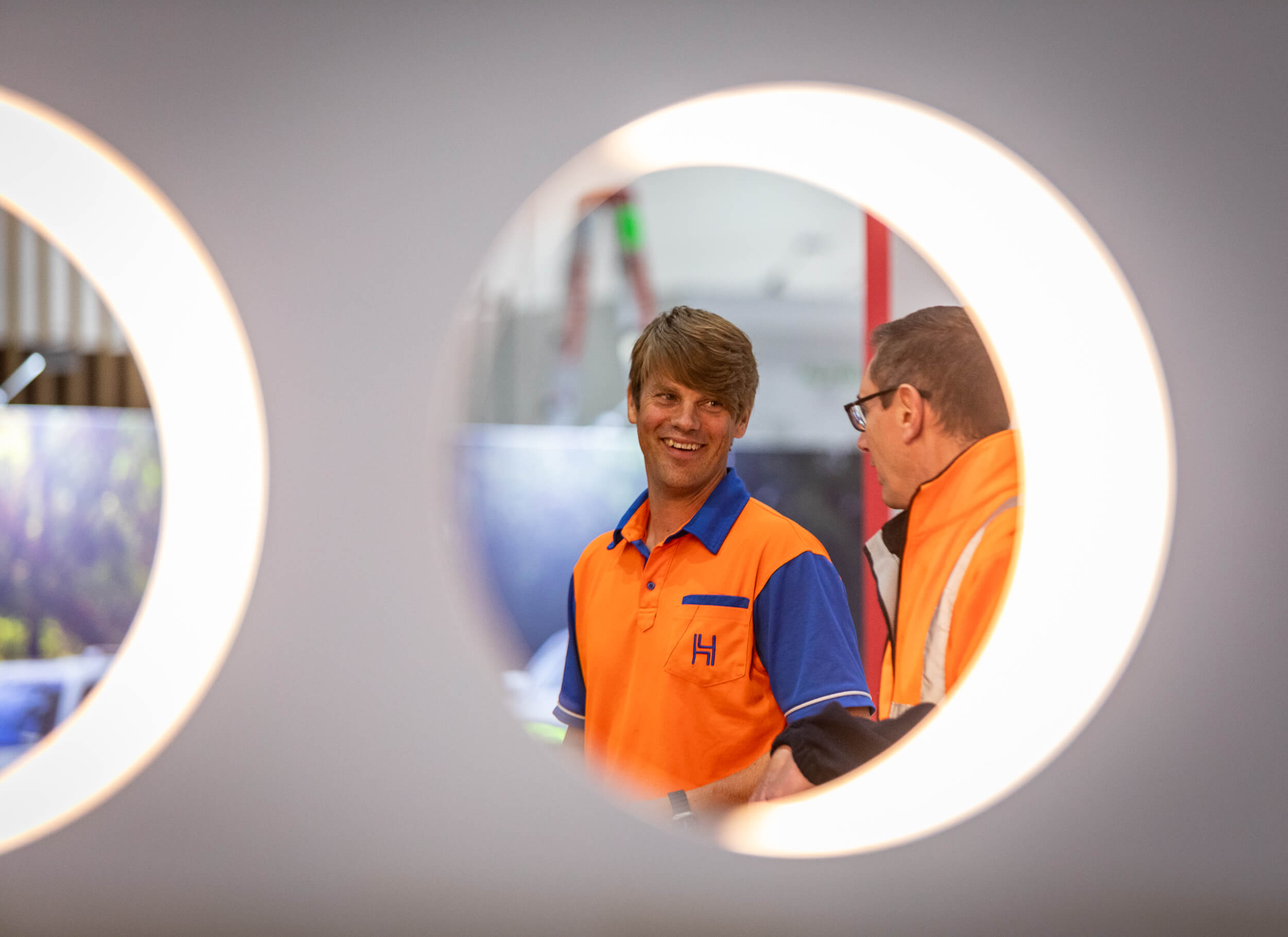 'Harry The Hirer team members' smiling while building an exhibition stand on site.