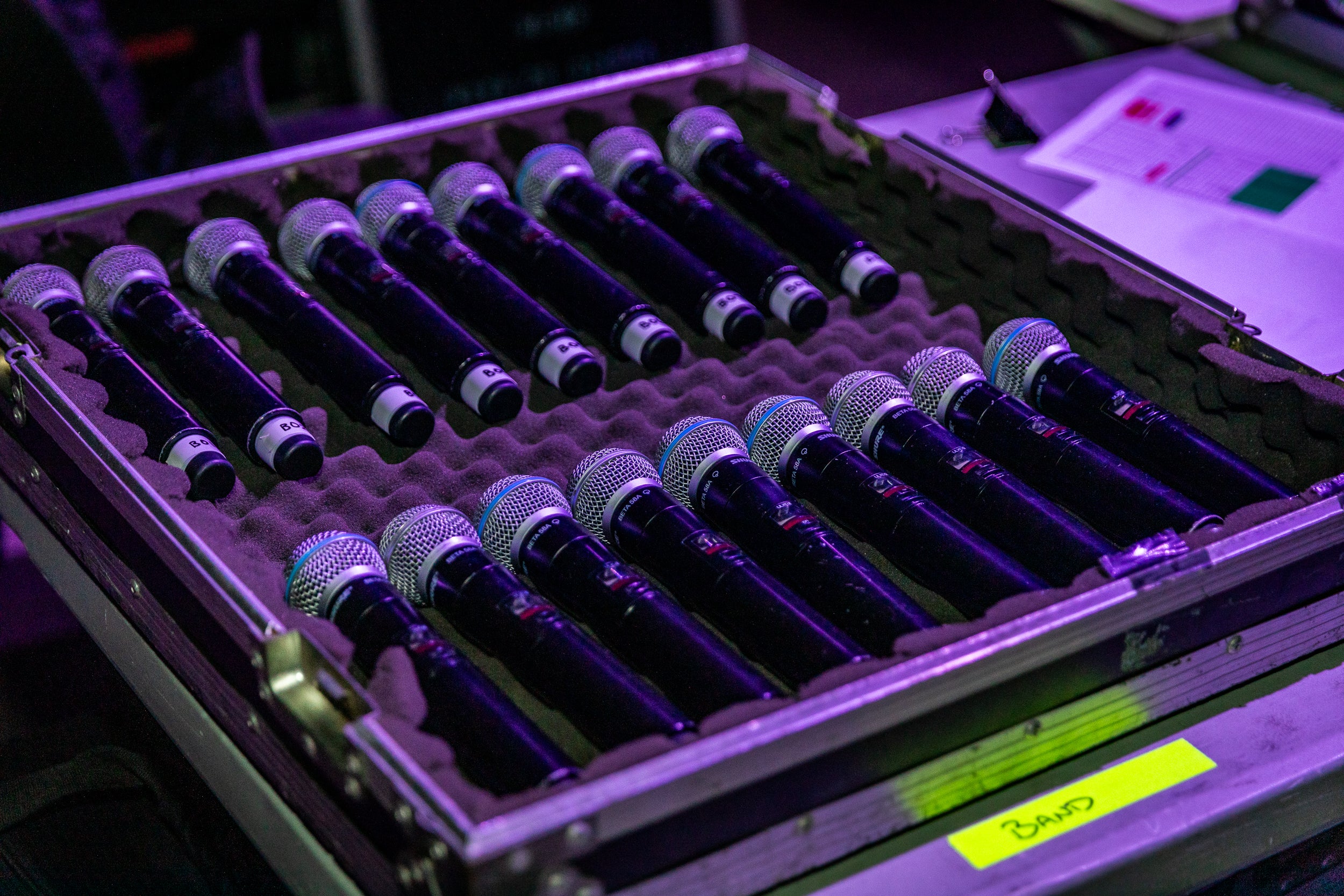 Row of microphones in a case with a purple hue