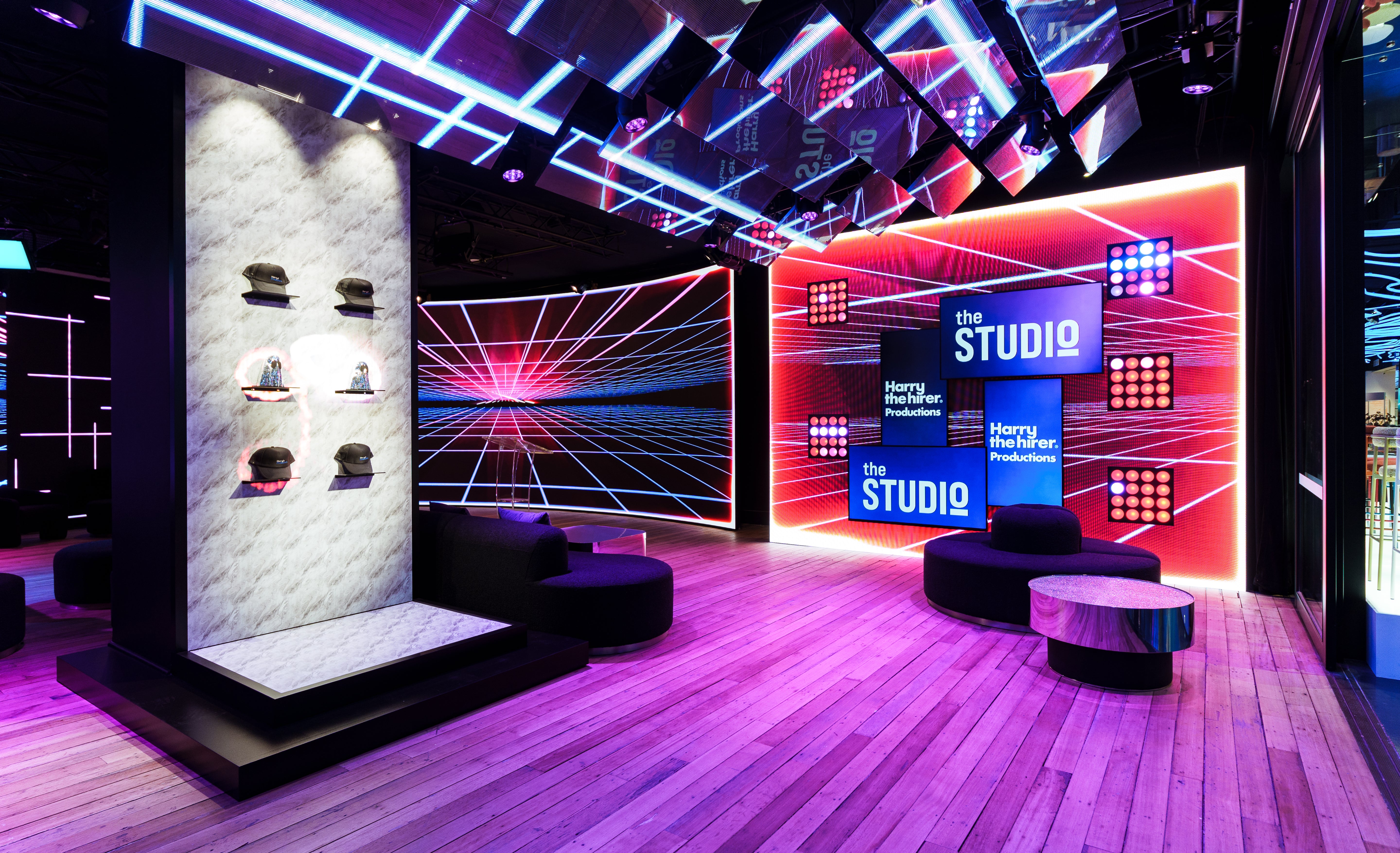 Modern studio interior with colorful lighting and digital displays.