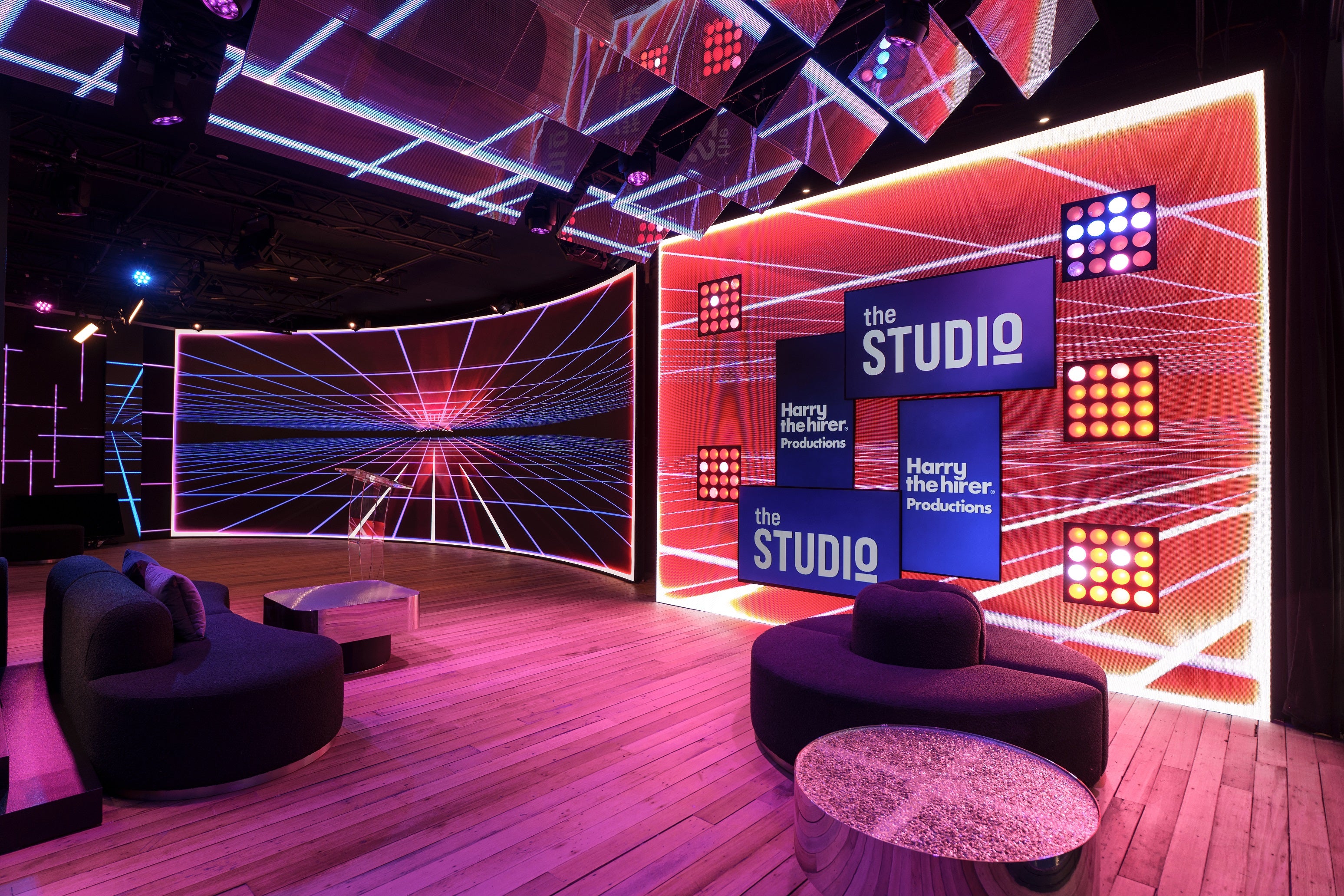 Modern studio interior with 'The Studio' branding, colorful lighting, and futuristic design elements.