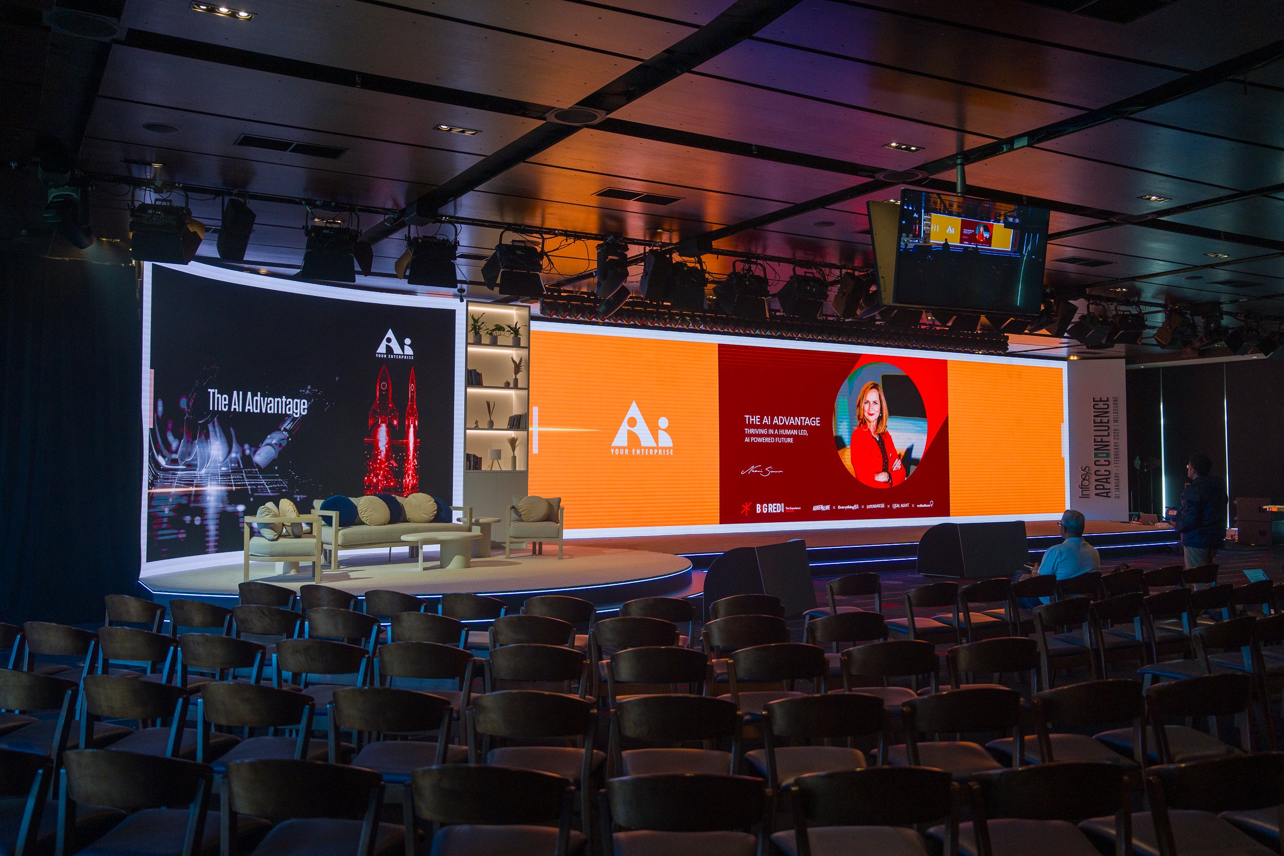 Empty conference room with large screens displaying a logo and text
