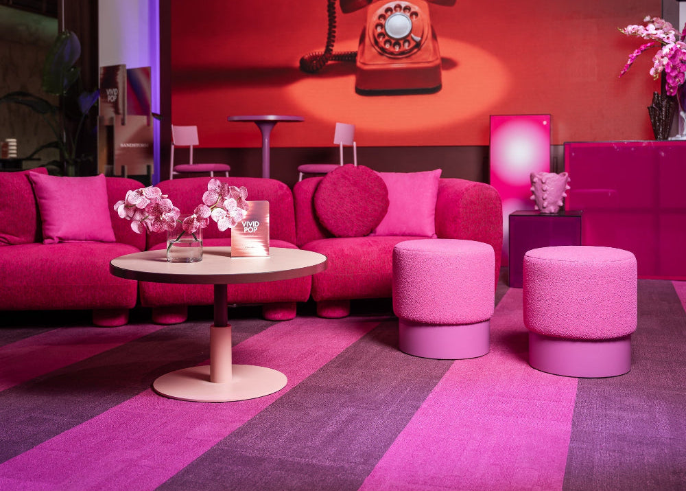 Modern interior with pink furniture and a retro telephone on a red wall.