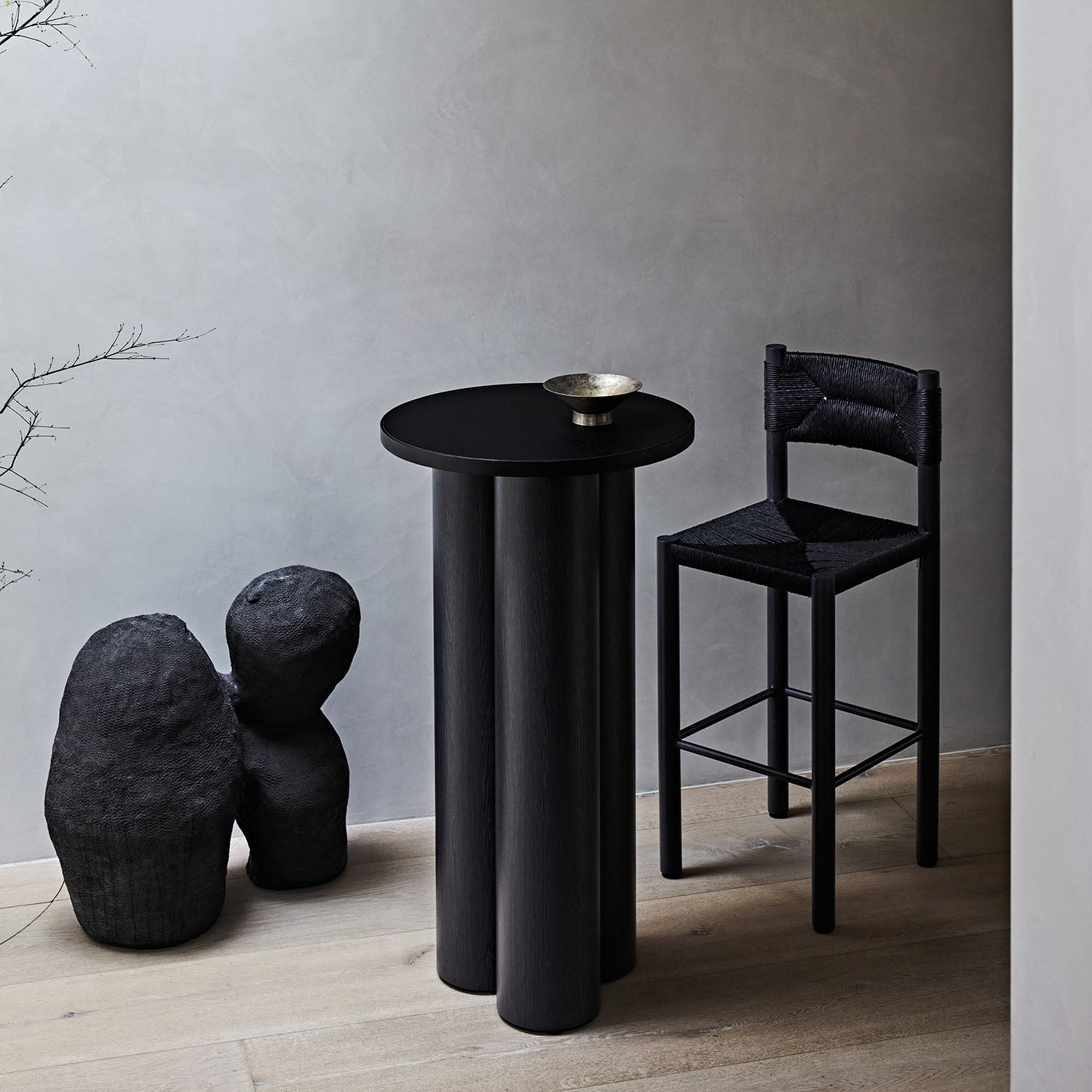 Black Casa stool and high table against a gray wall