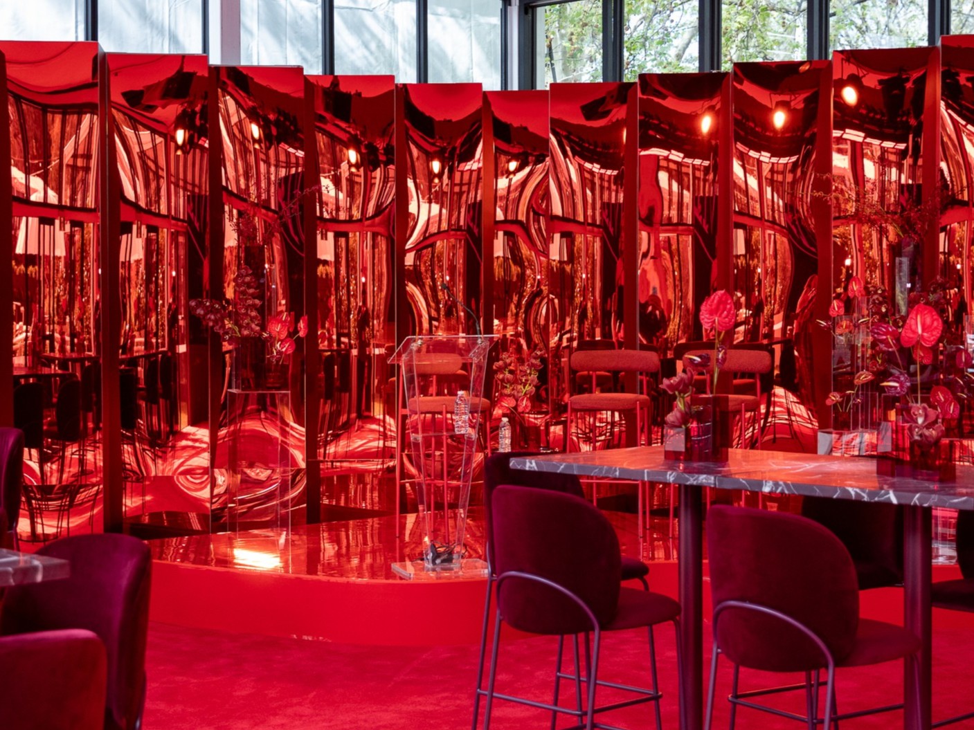 Modern marquee interior with red chairs and custom reflective walls.