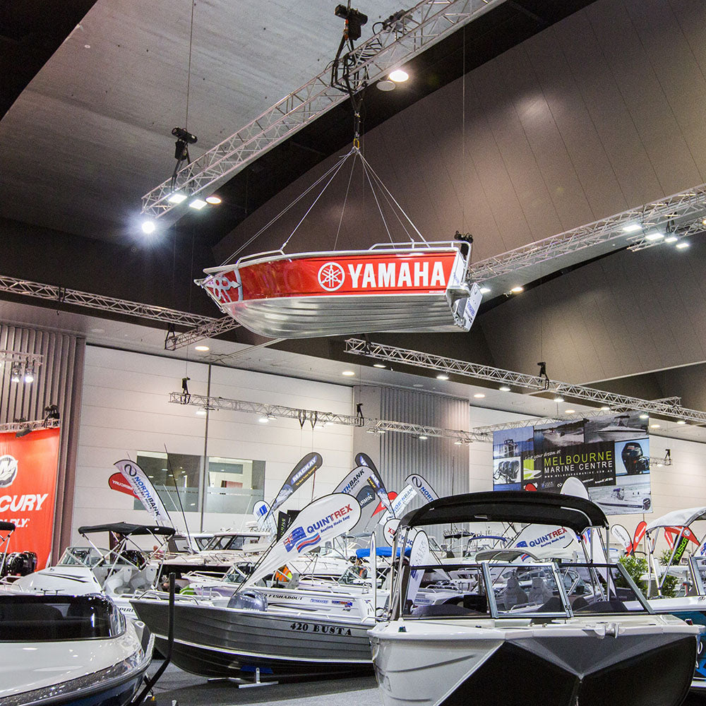 Yamaha boat rigged and on display at a boat show with other boats in the background.
