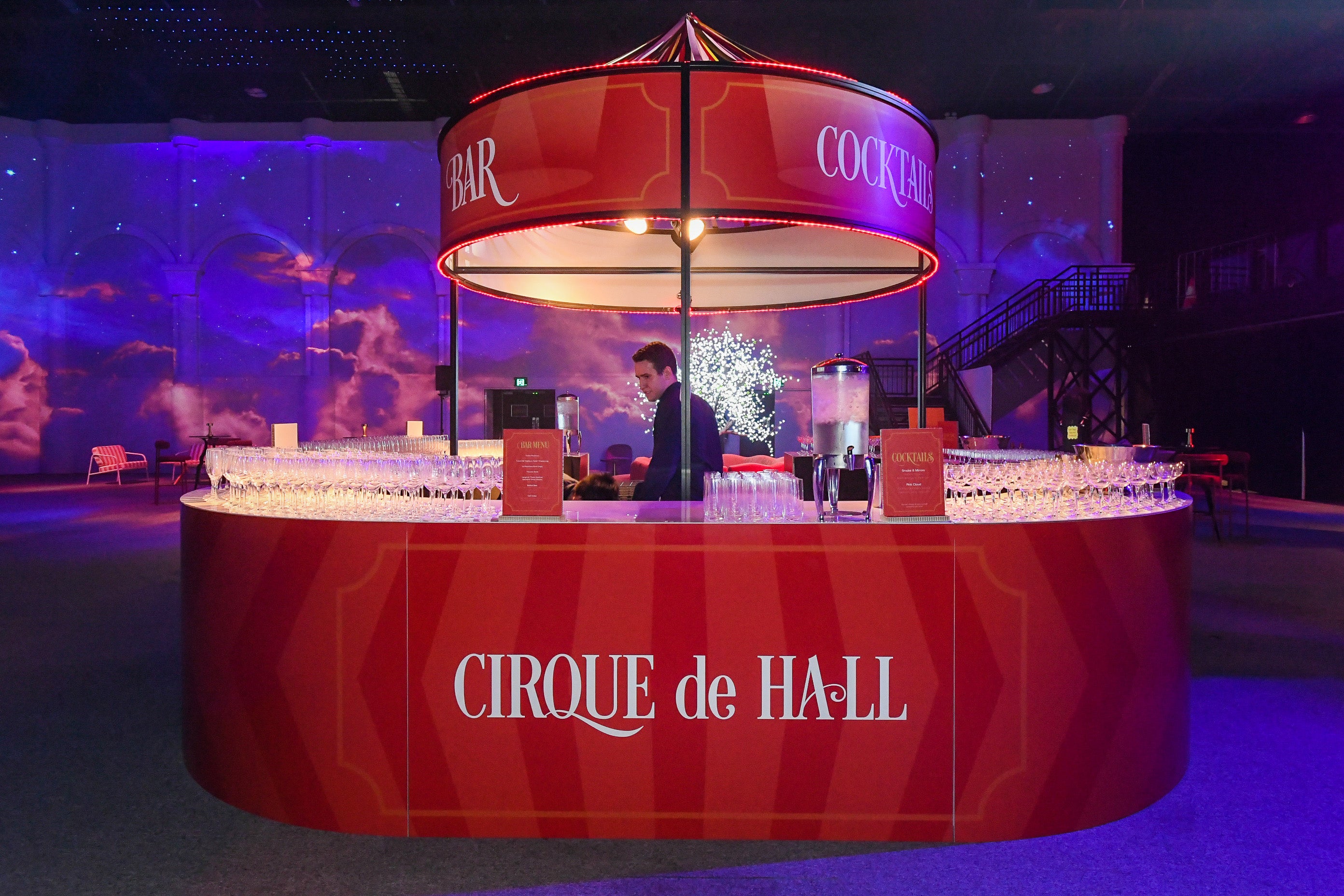 Red circular bar with 'Cirque de Hall' branding in a dimly lit room.