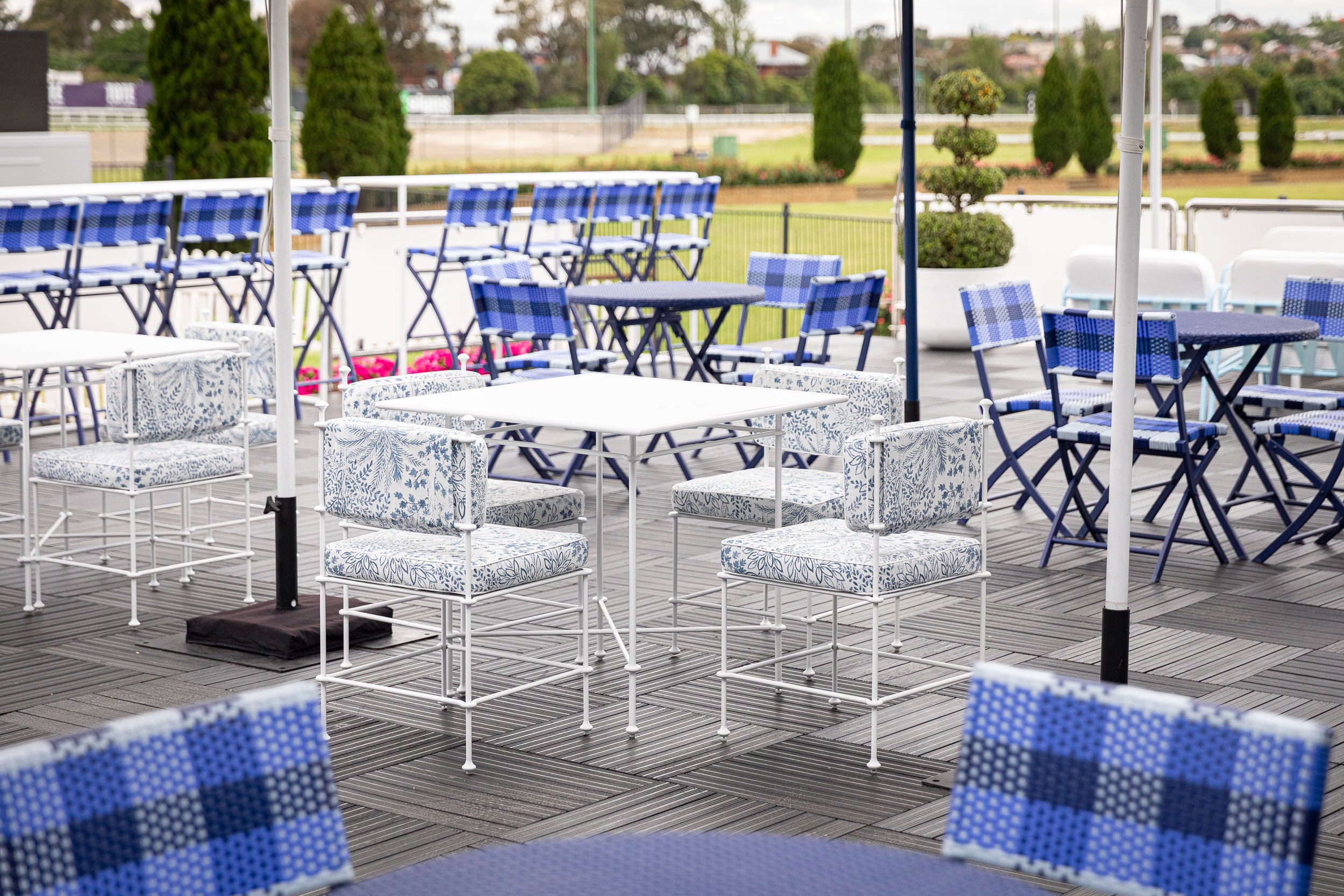 Outdoor seating area with tables and chairs on a wooden deck at Spring Racing Carnival