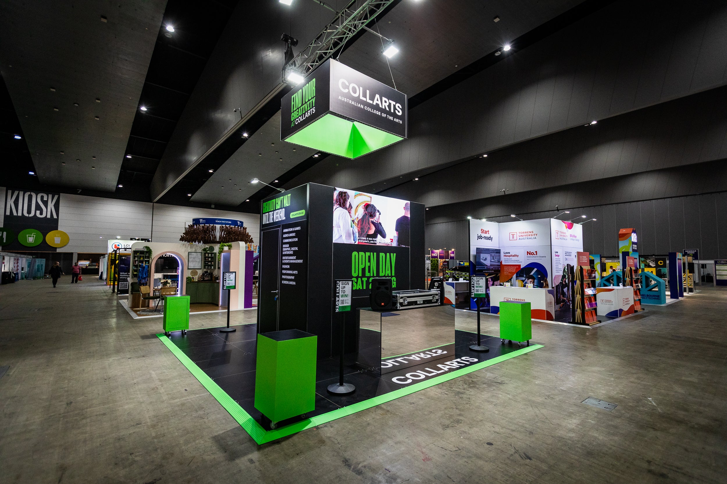 Exhibition hall with booths and a prominent 'Collarts' booth in the center.
