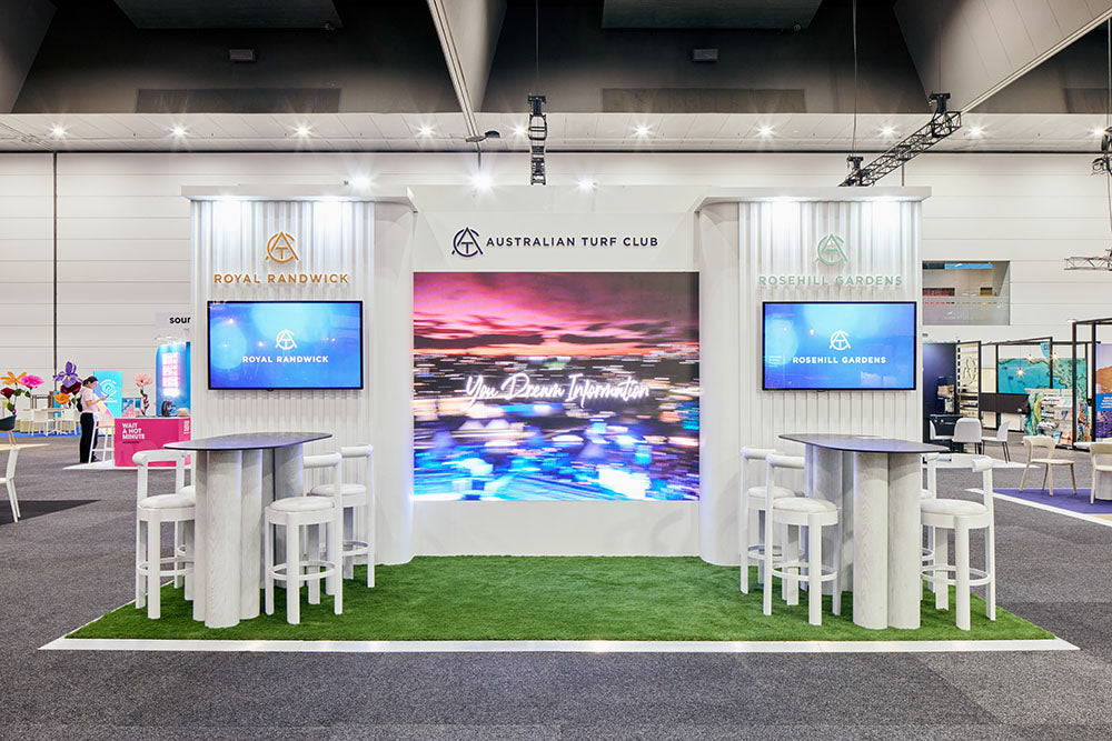Exhibition stand with digital screens and promotional materials at anexpo. AIME 2026.
