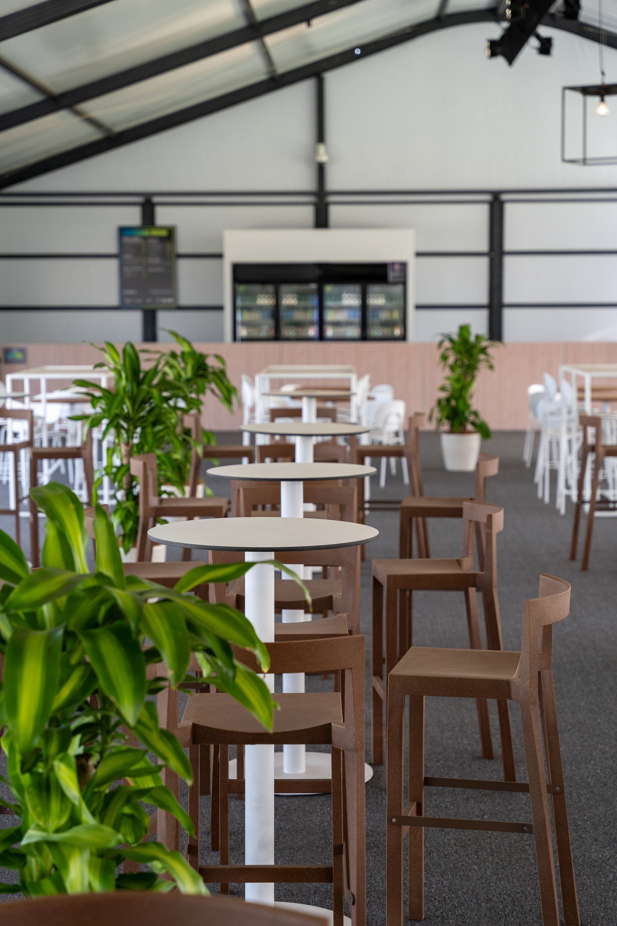 Large indoor space with tables, chairs, and plants
