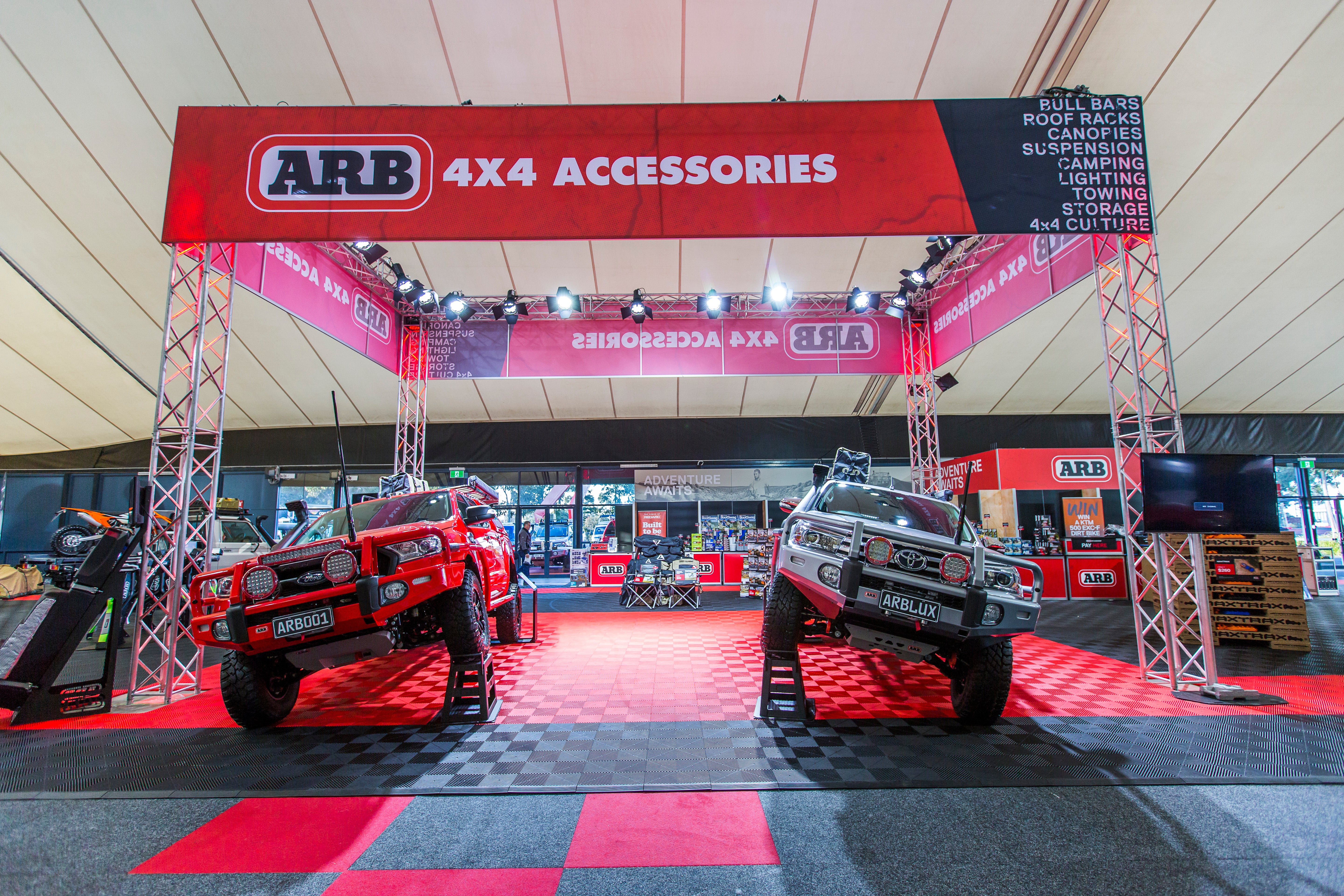 Display of 4x4 vehicles with ARB 4x4 Accessories branding at an exhibition.