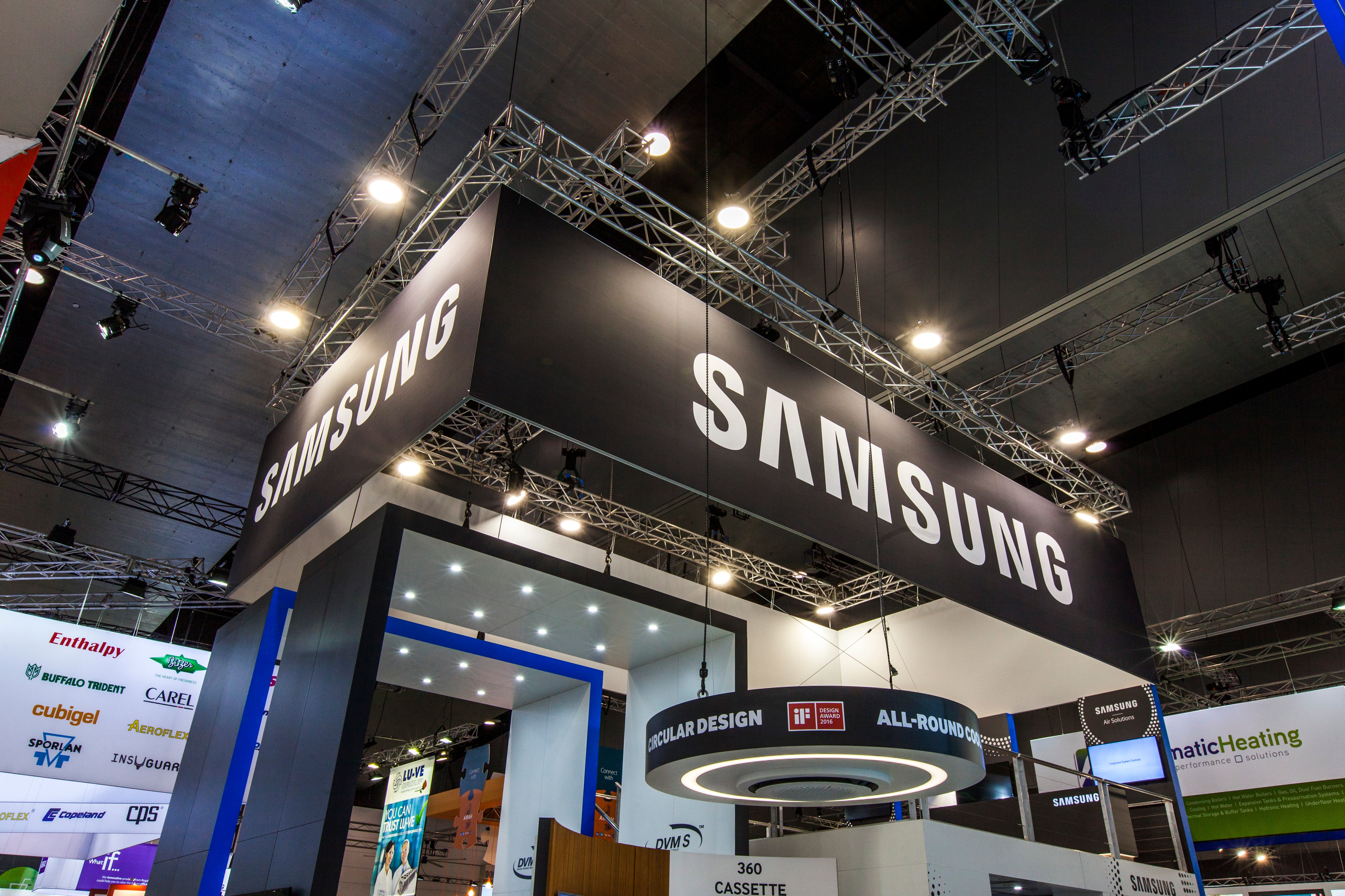 Samsung booth at a trade show with various brand logos displayed.