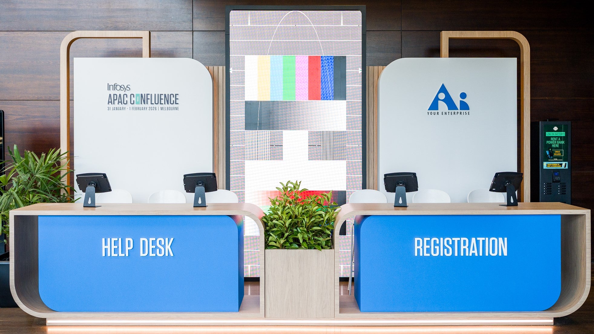 Registration and help desk setup with branding and event name on screens.