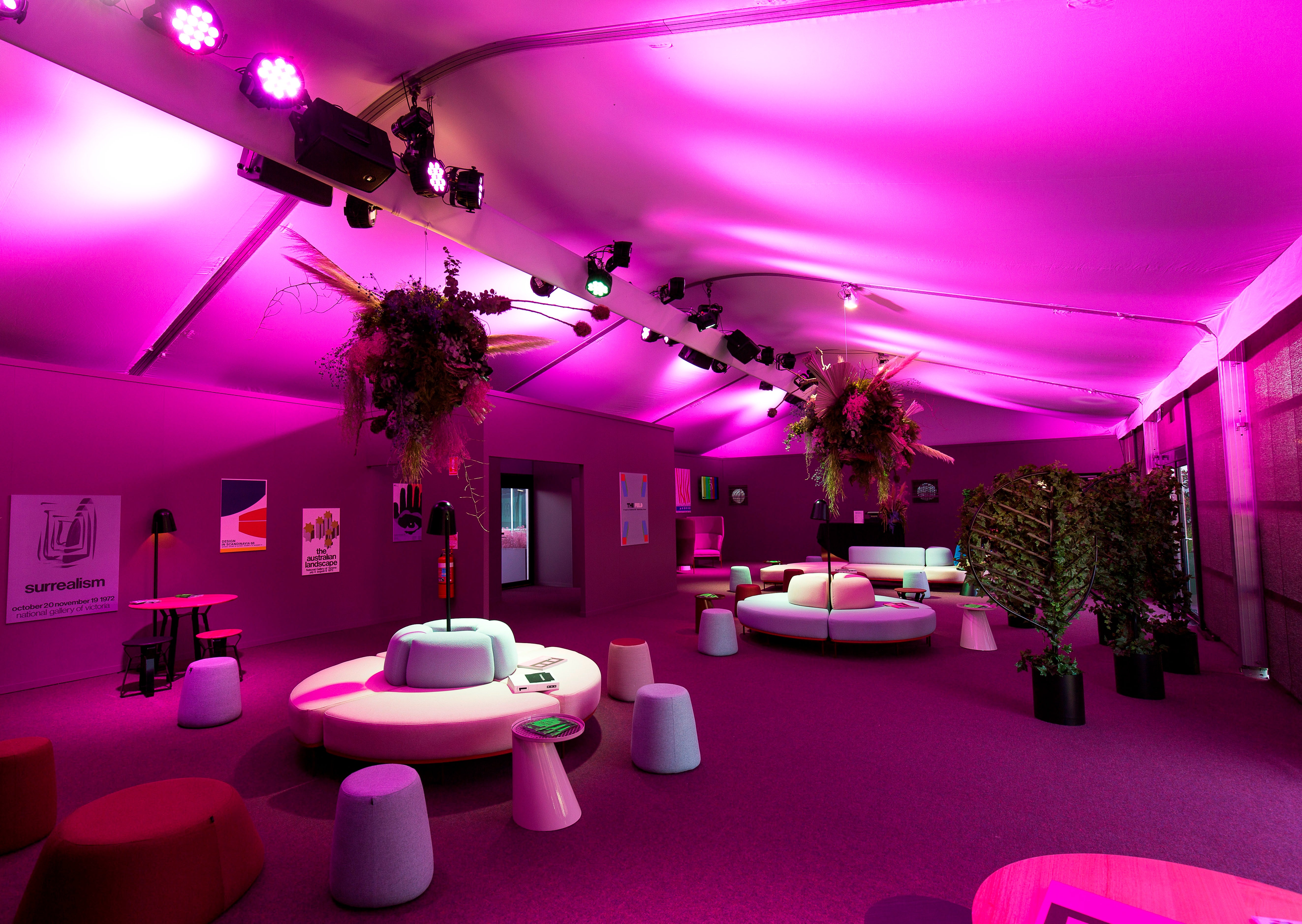 A marquee interior with purple lighting, furniture, and decor.