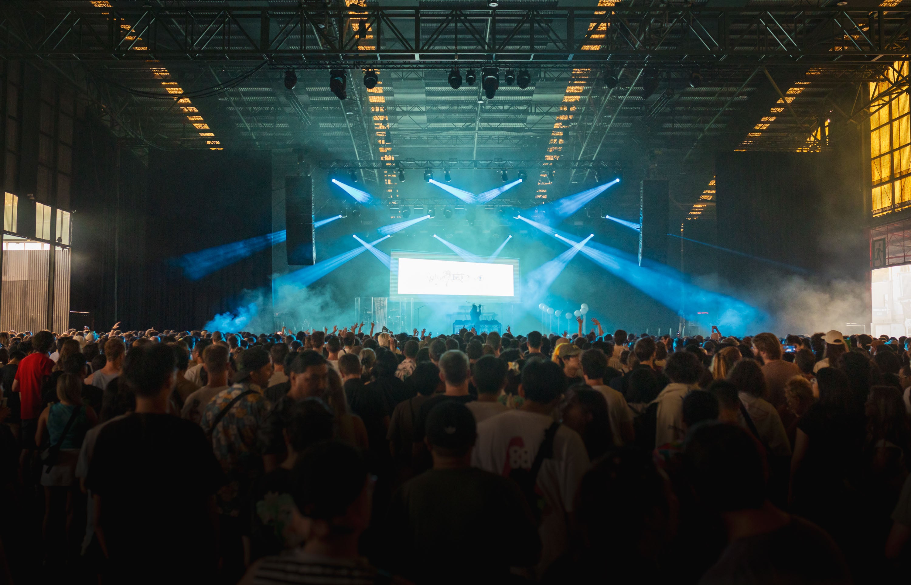 Large indoor event with stage, crowd, and lighting effects