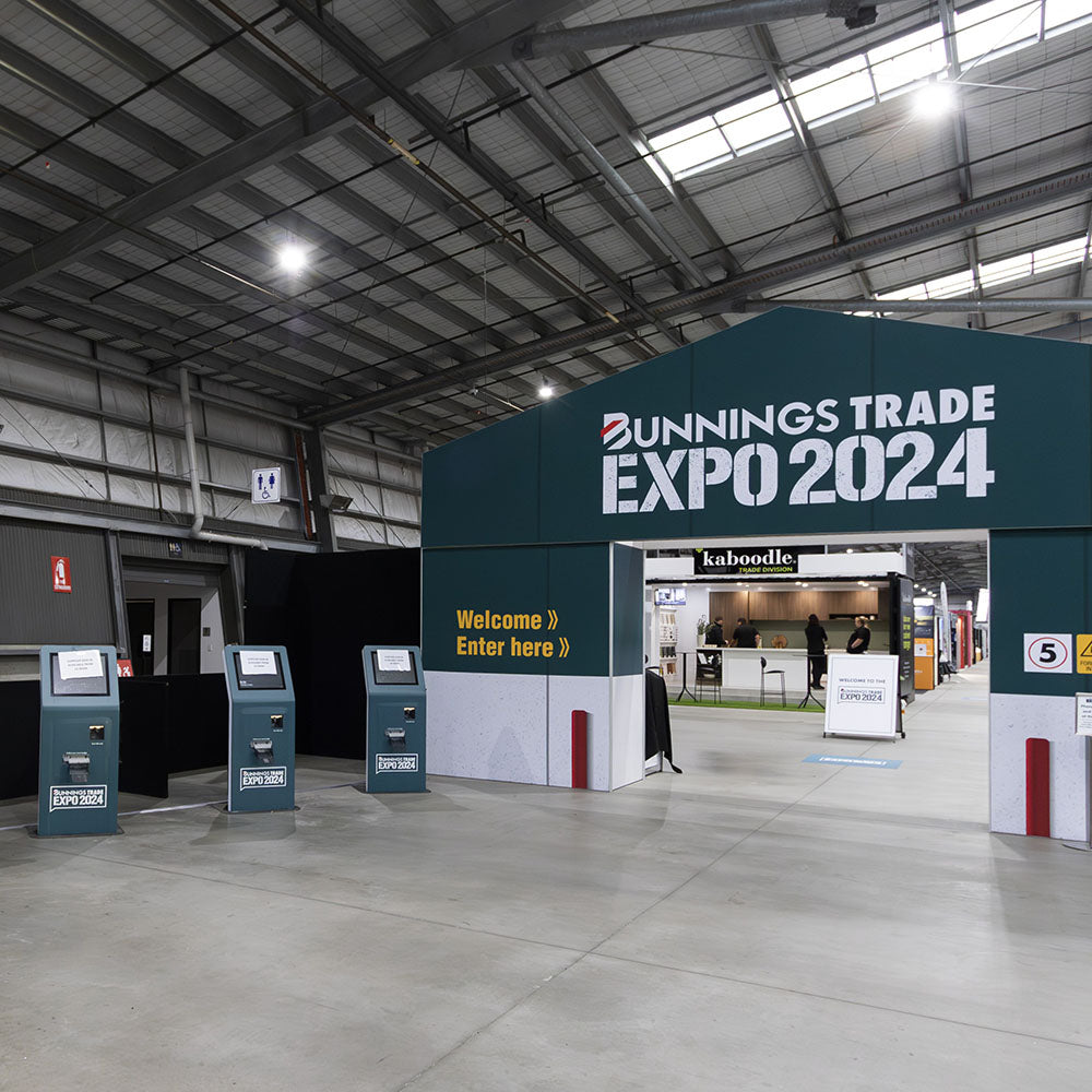 Bunnings Trade Expo 2024 entrance with signage and booths inside a large indoor hall.