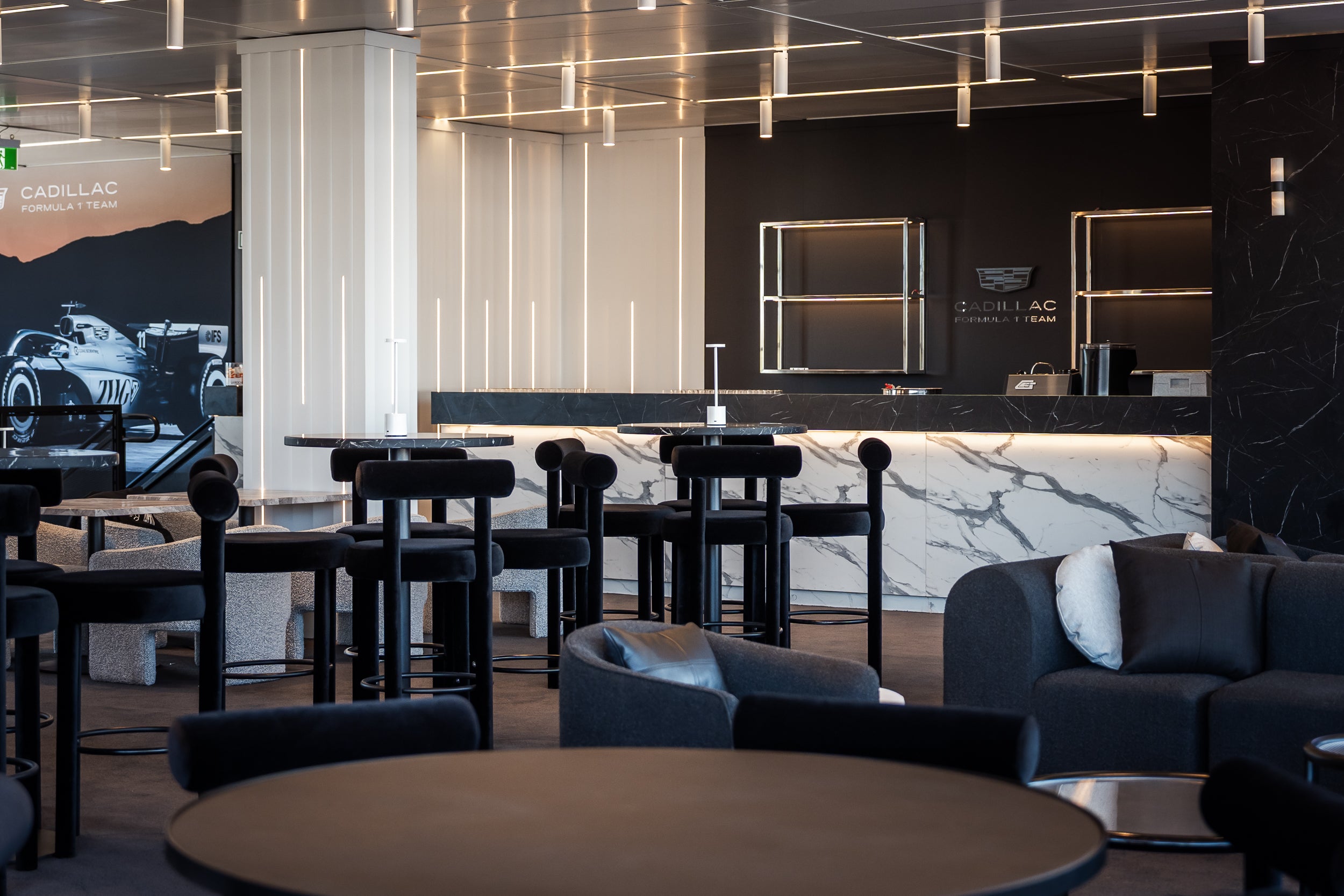 Modern interior of a lounge or waiting area with tables, chairs, and a counter.