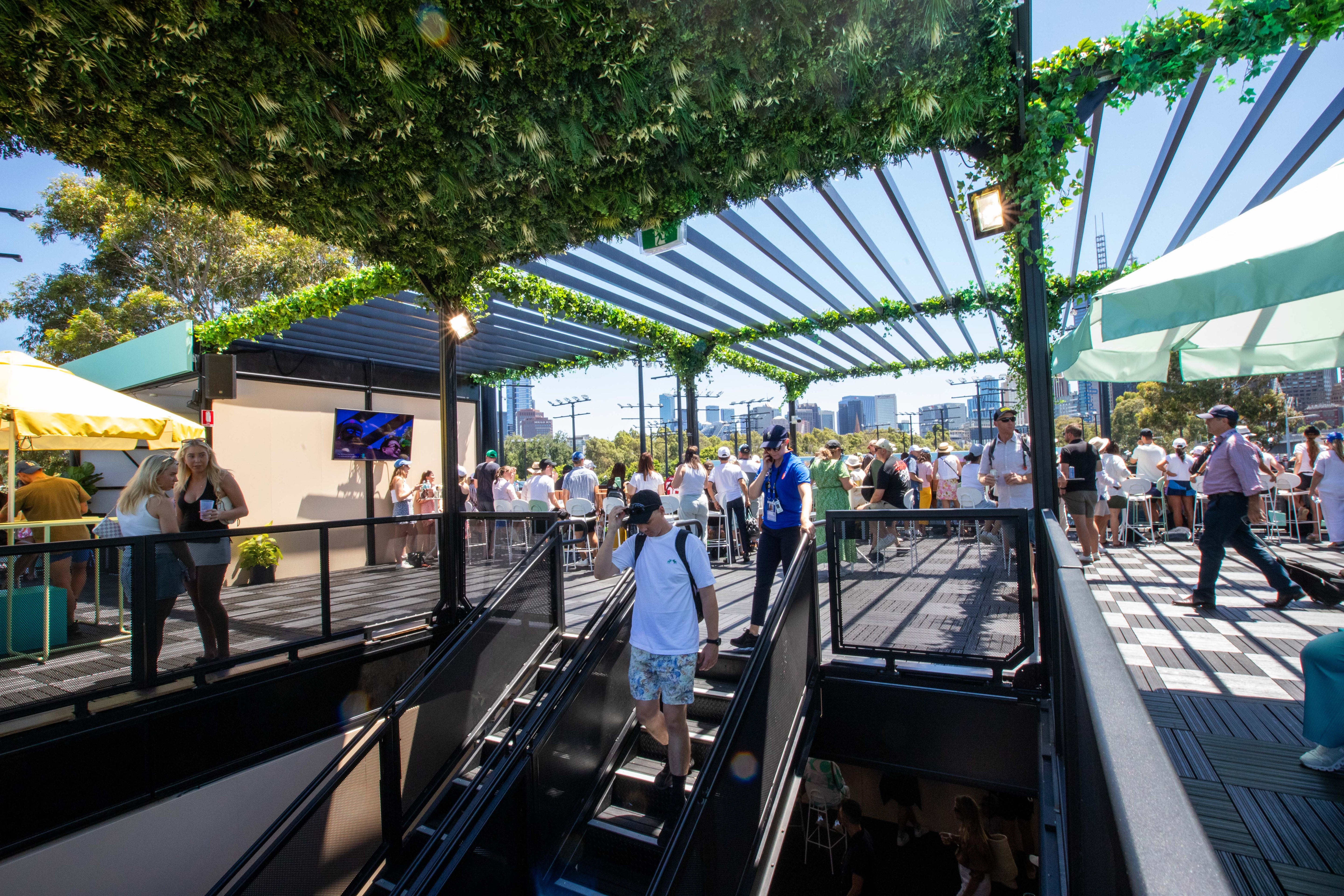 People walking up and down stairs in a highline marquee