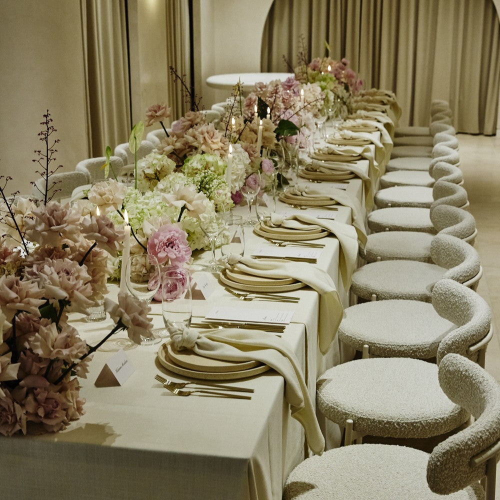 Elegant dining setup with floral arrangements and white tablecloth.