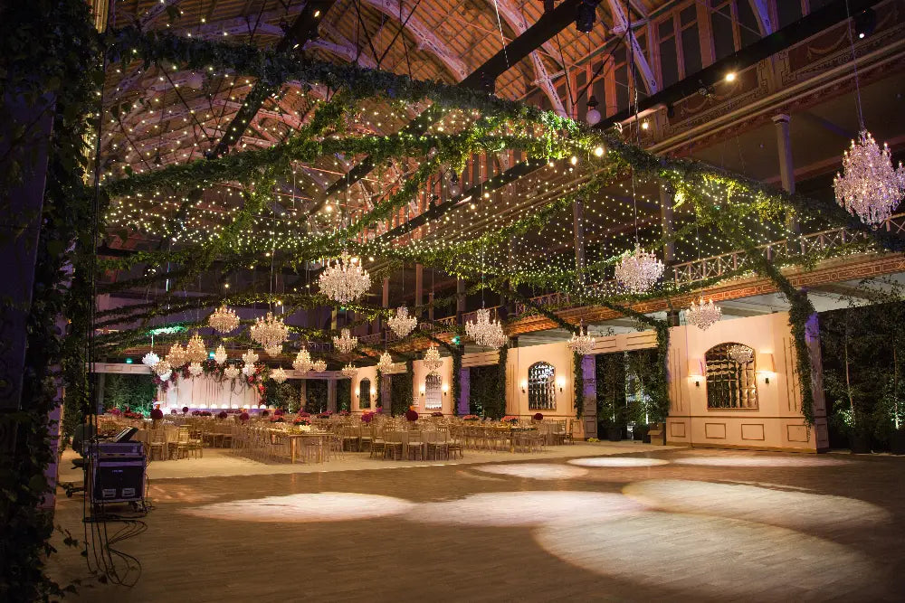 Decorative indoor setting with hanging lights and greenery, likely for a special event.