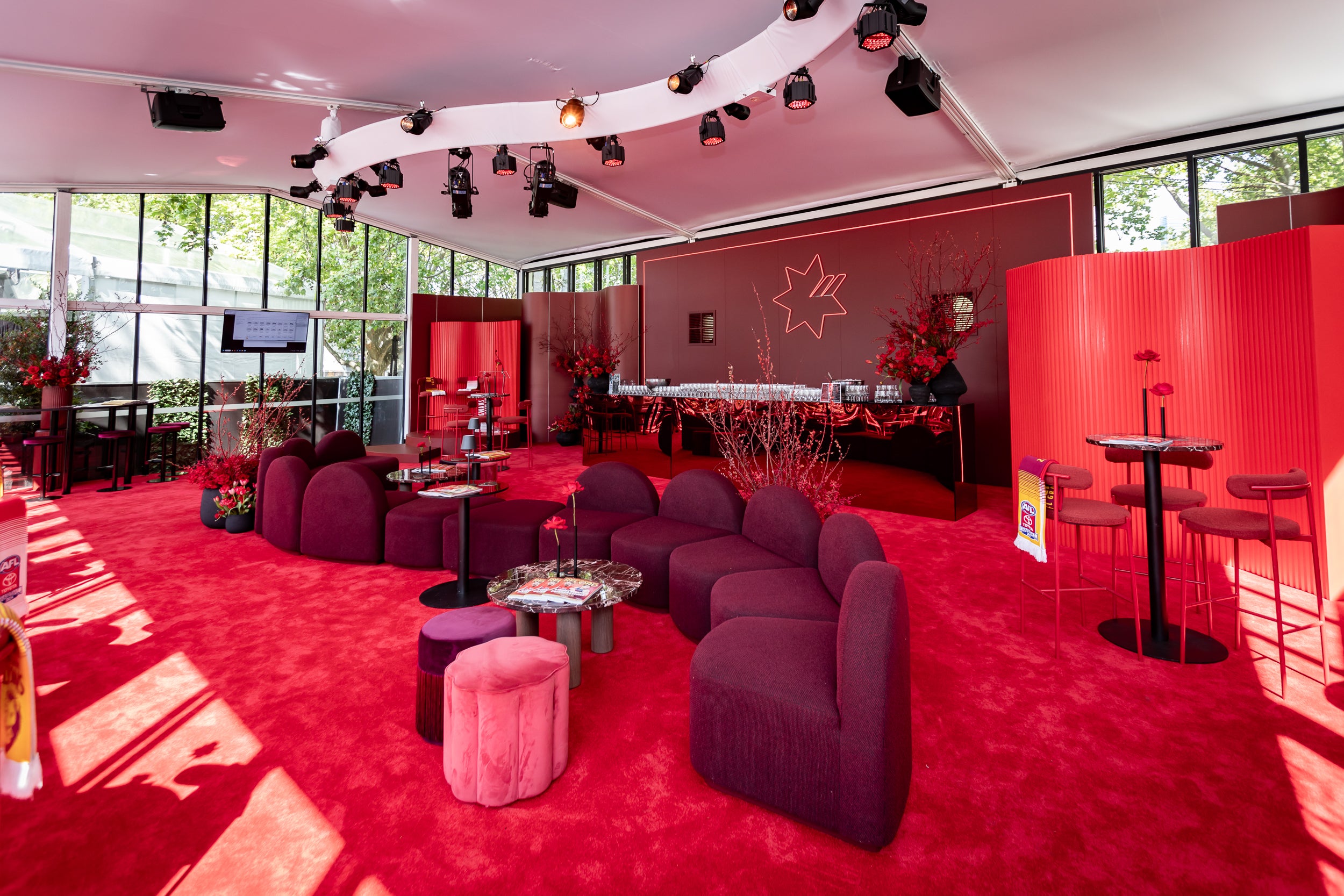 Modern interior with red carpet, purple furniture, and decorative elements inside a Marquee