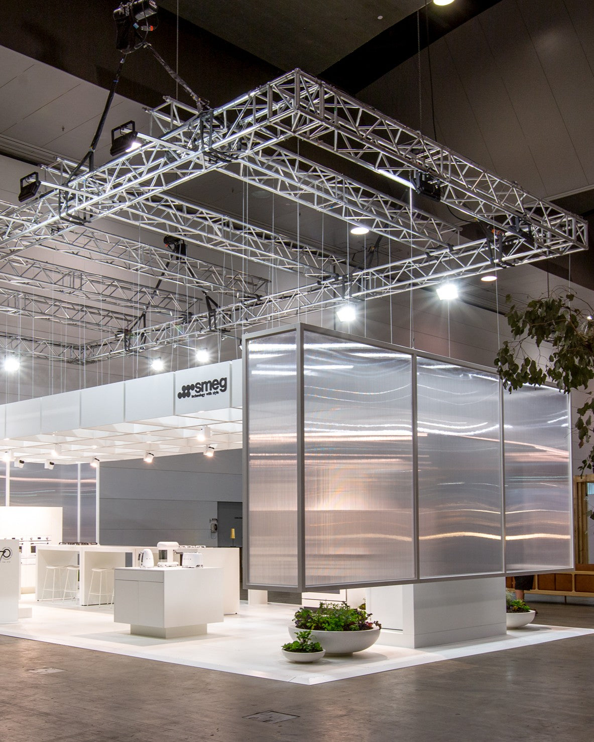 Modern kitchen display with Smeg appliances at a trade show. Rigged walls are up to close off the space