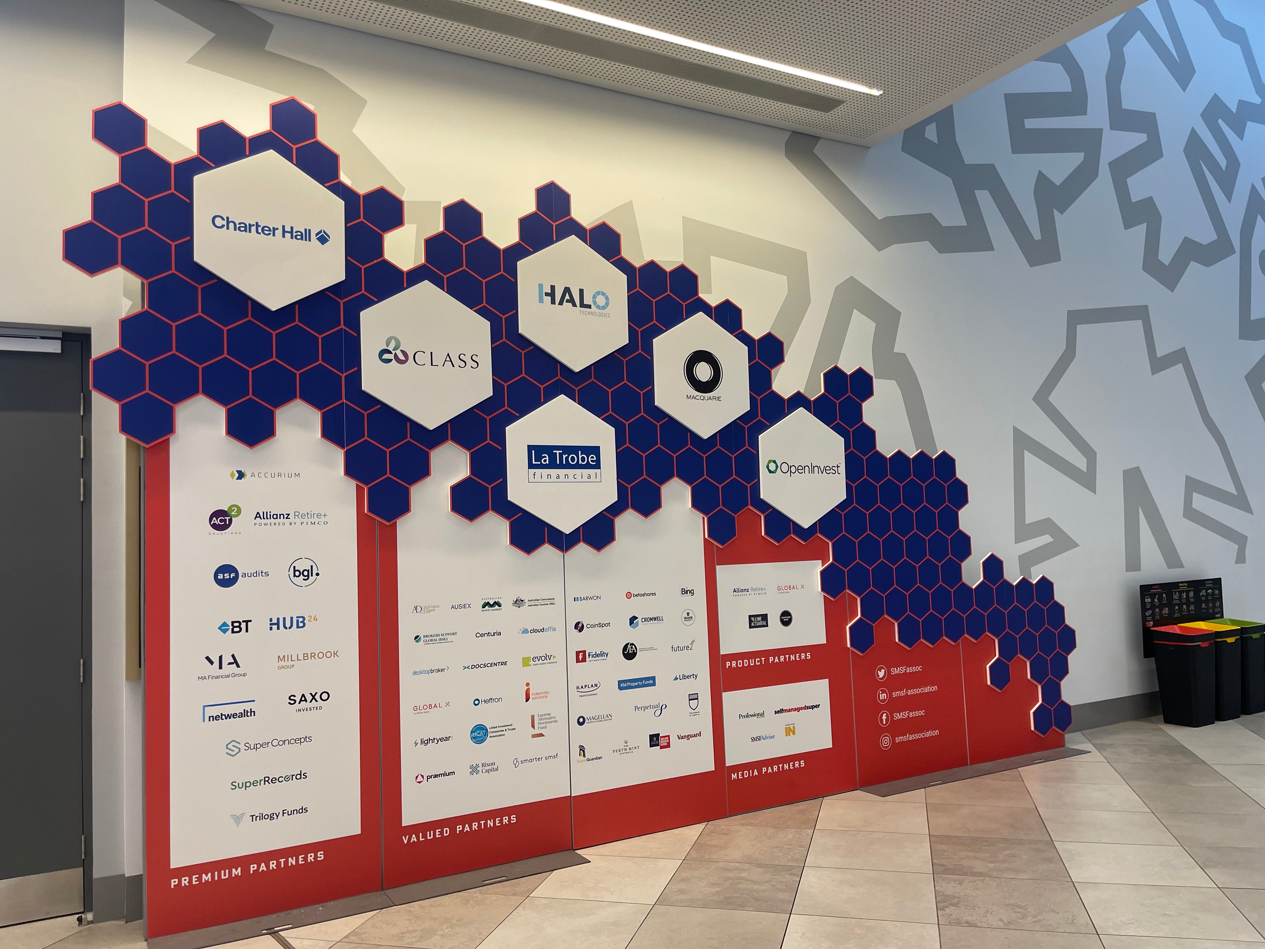 Hexagonal tile wall with brand logos in an indoor setting