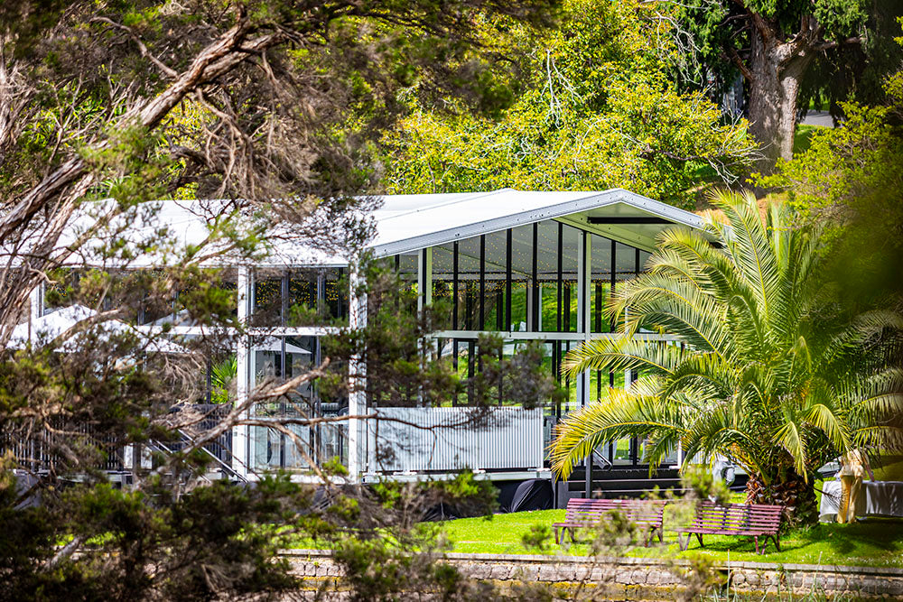 Alto Marquee with large glass windows surrounded by trees and a bench