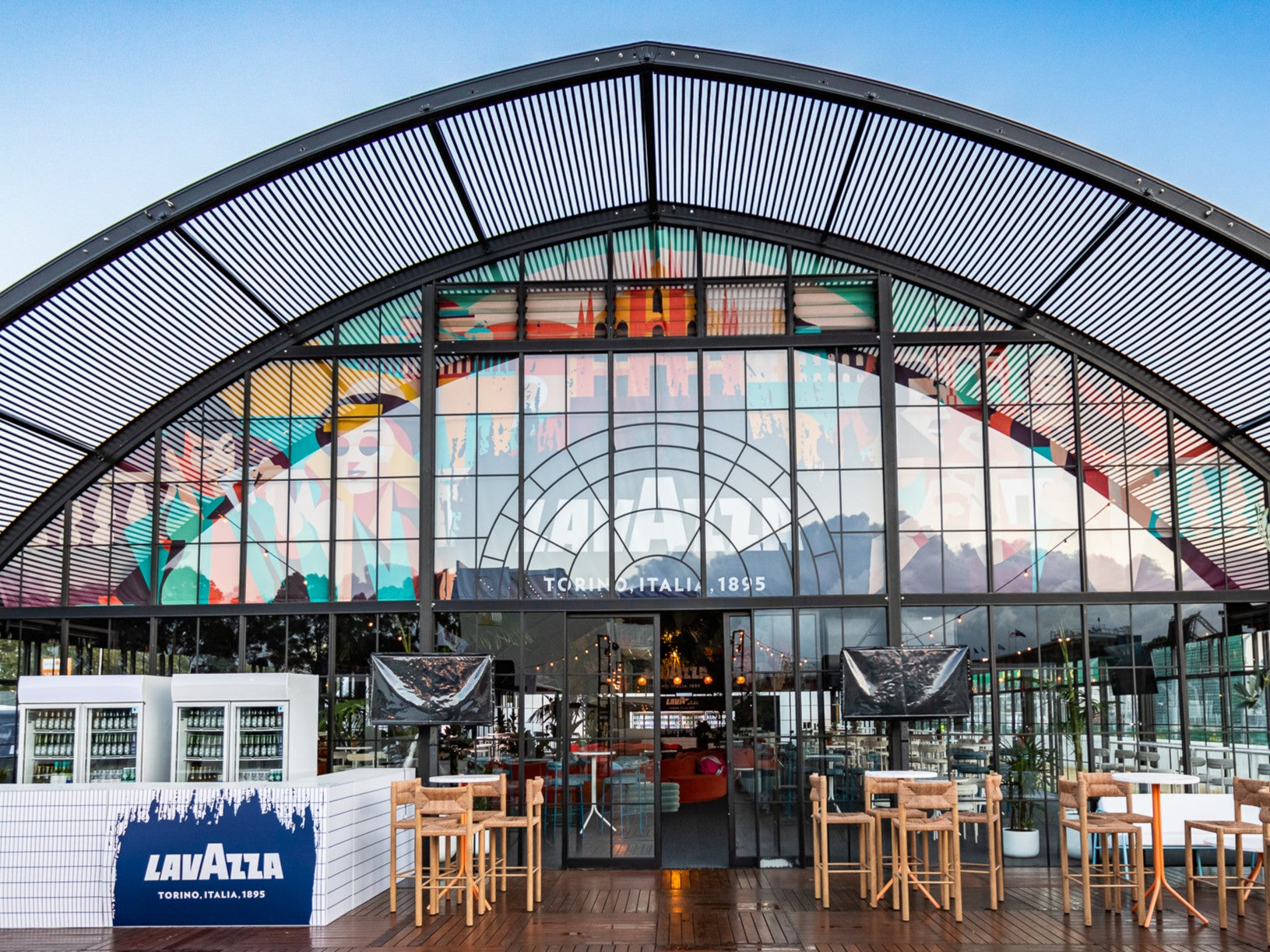 Atrium Marquee with large glass facade and outdoor seating area, featuring a Lavazza sign.