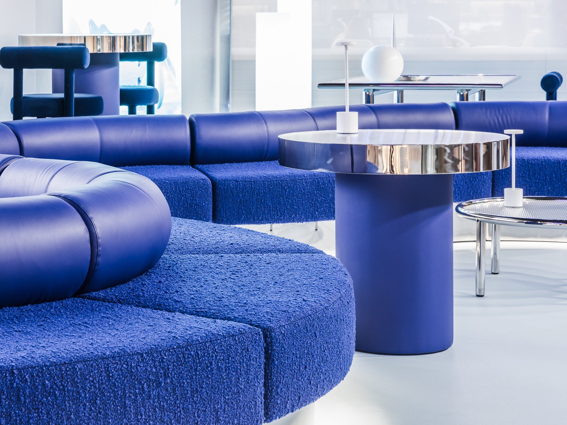 Zeon blue sofa with a round metallic table in a bright room