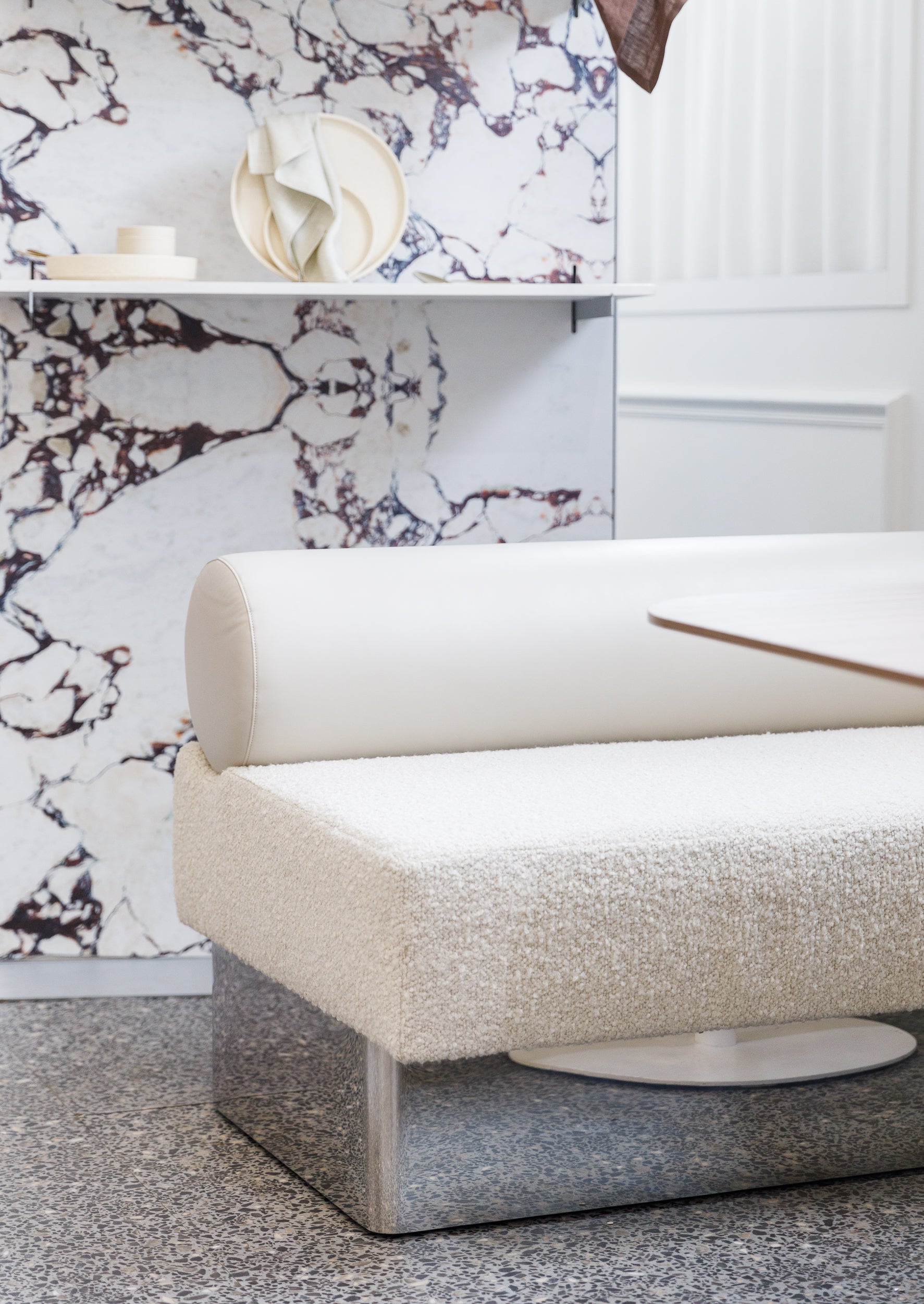 Modern white sofa with textured seat against a patterned wall