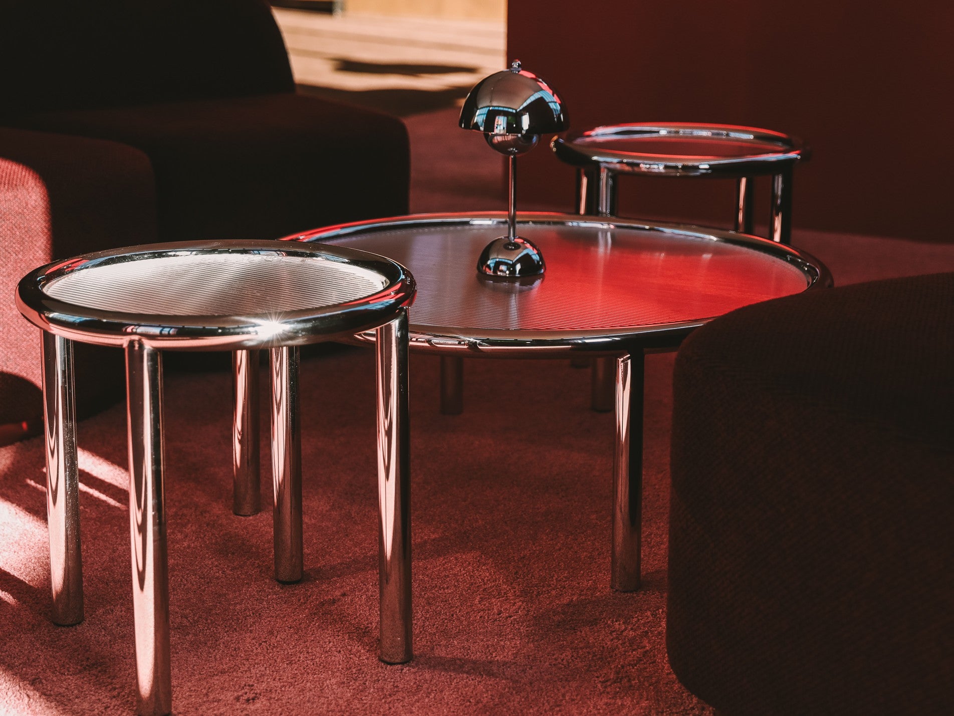 Two round tables with metallic bases in a room setting