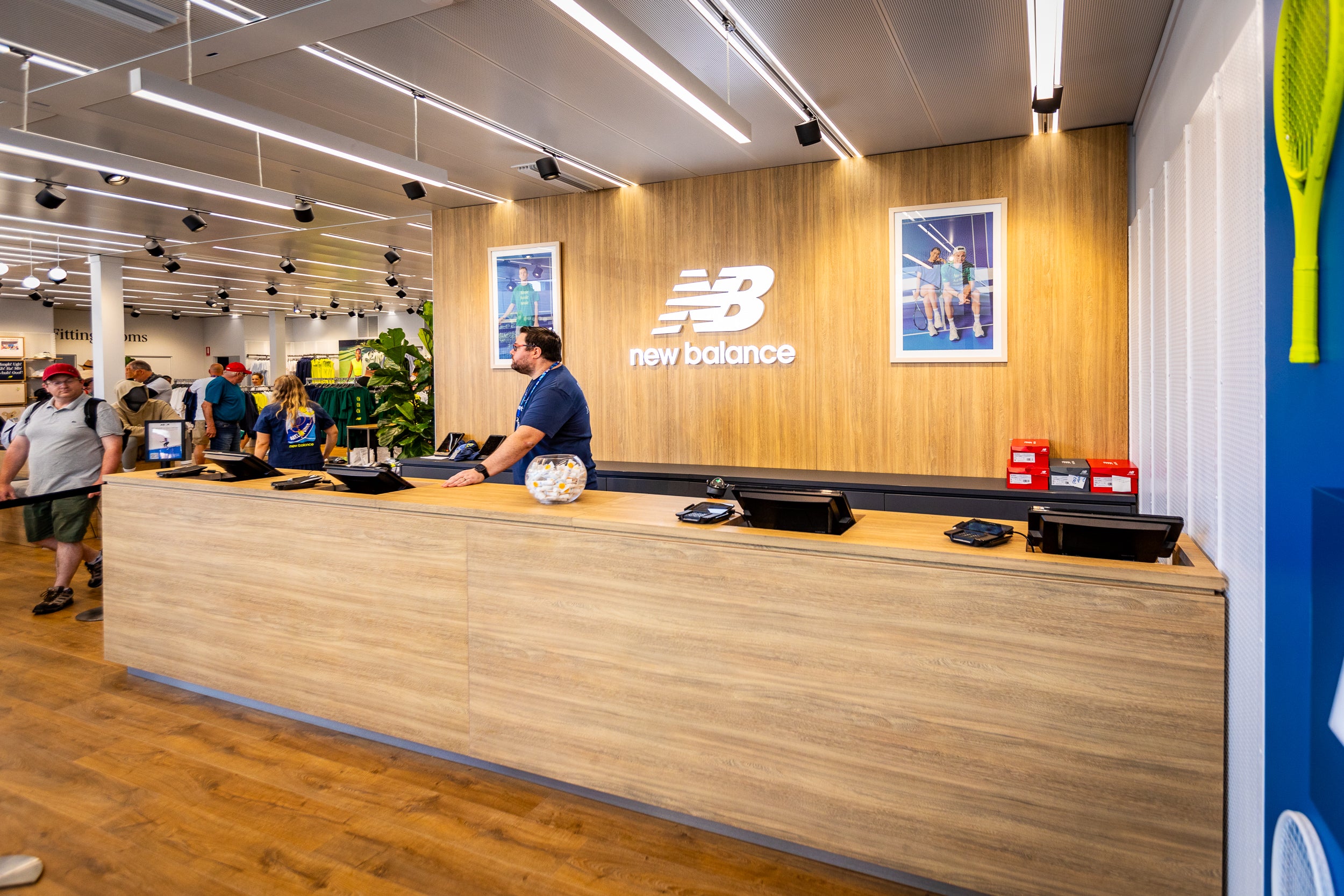 Customer service desk in a New Balance store with employees and customers.