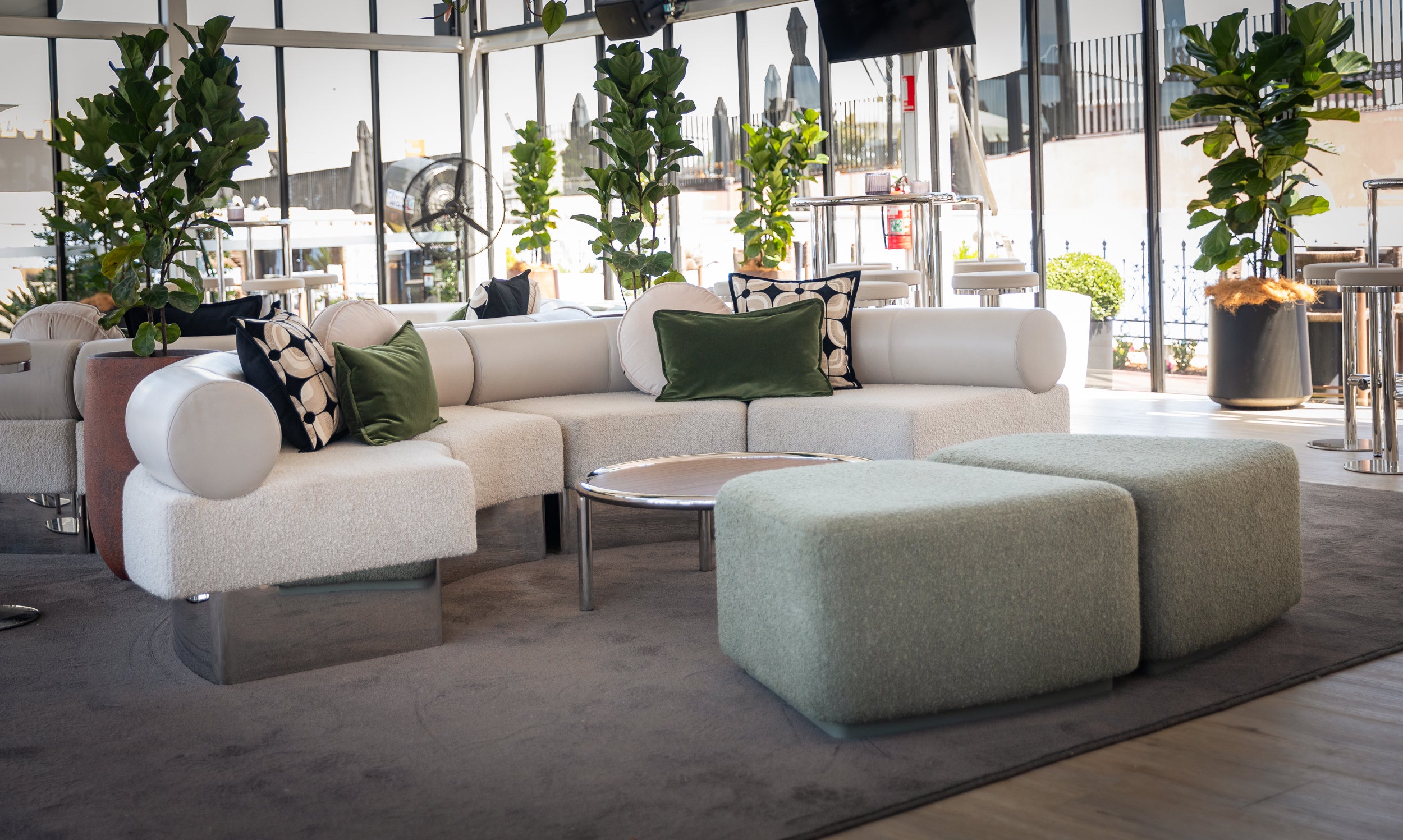 Modern living room with a sectional sofa, ottoman, and decorative pillows.