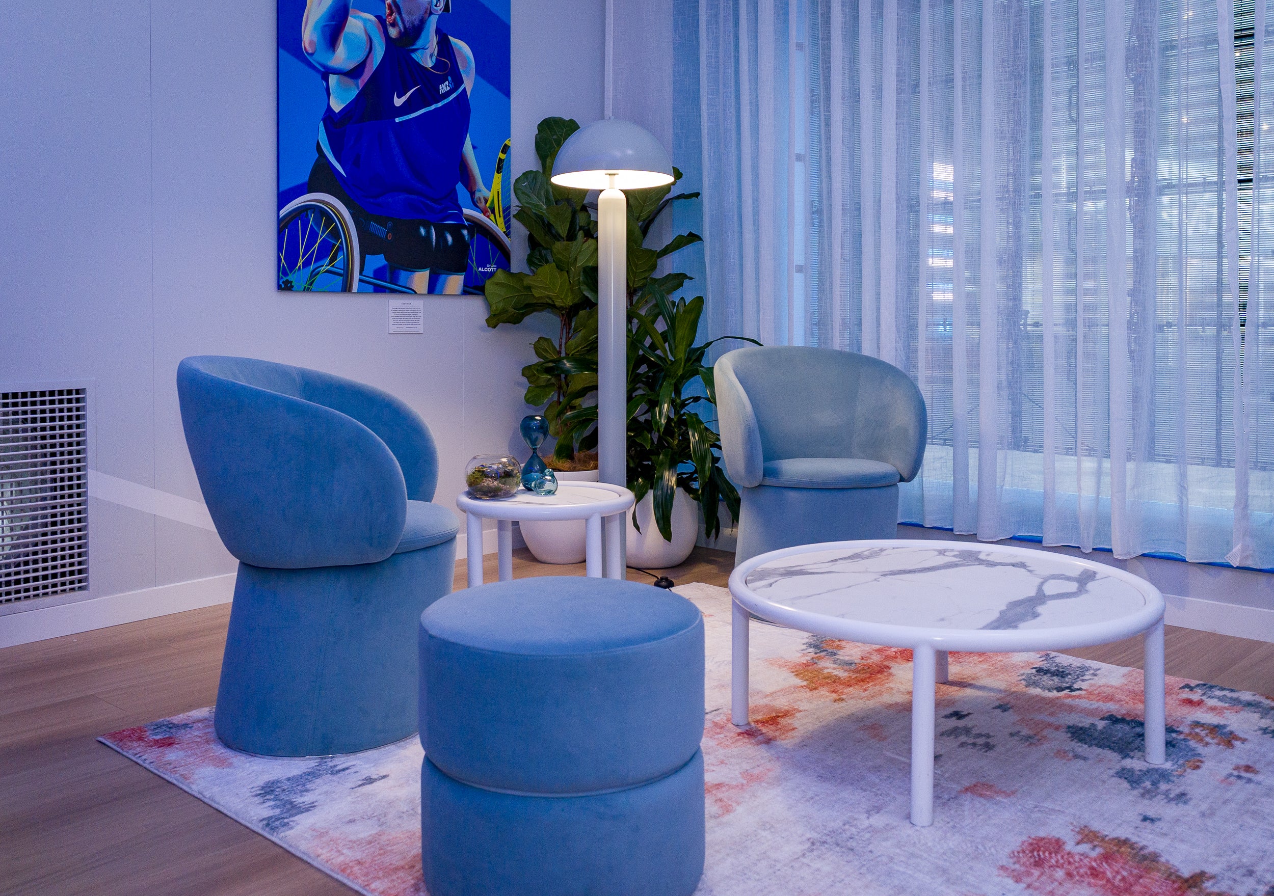 Modern seating area in our marquee with blue chairs, a white coffee table, and decorative elements, all hired furniture. Pictured at Australian open.