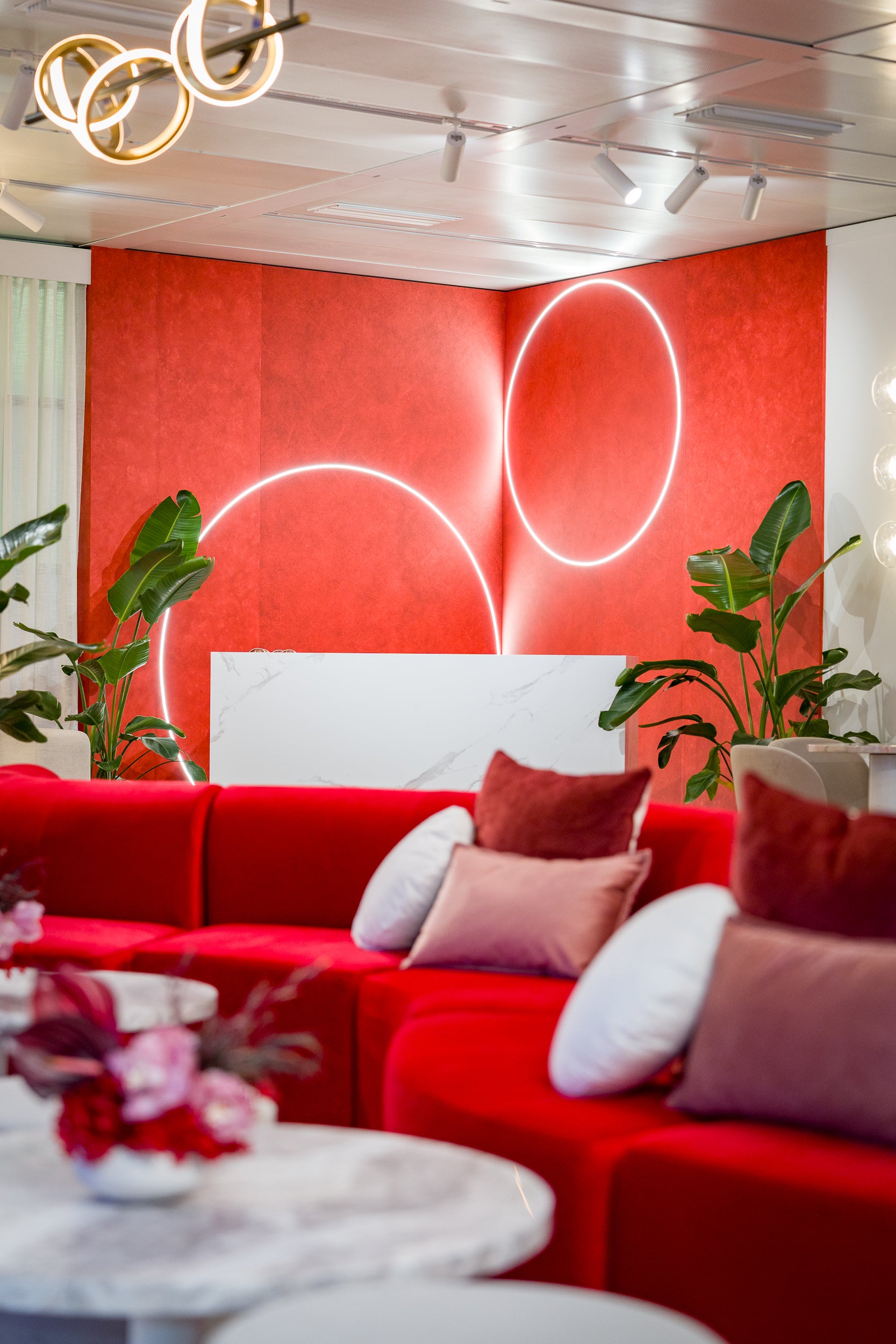 Modern interior with red sofa, white headboard, and decorative elements.