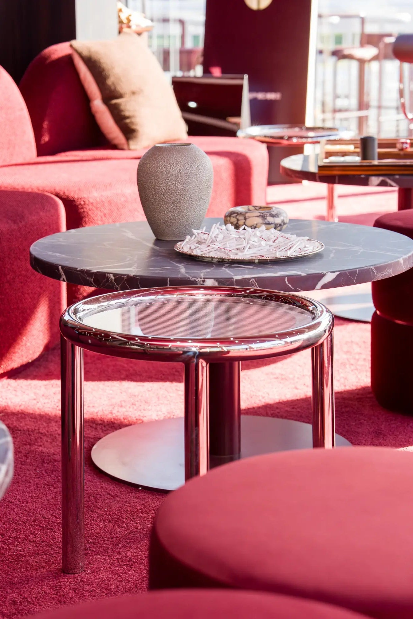 Modern interior with red upholstered furniture and a glass coffee table.
