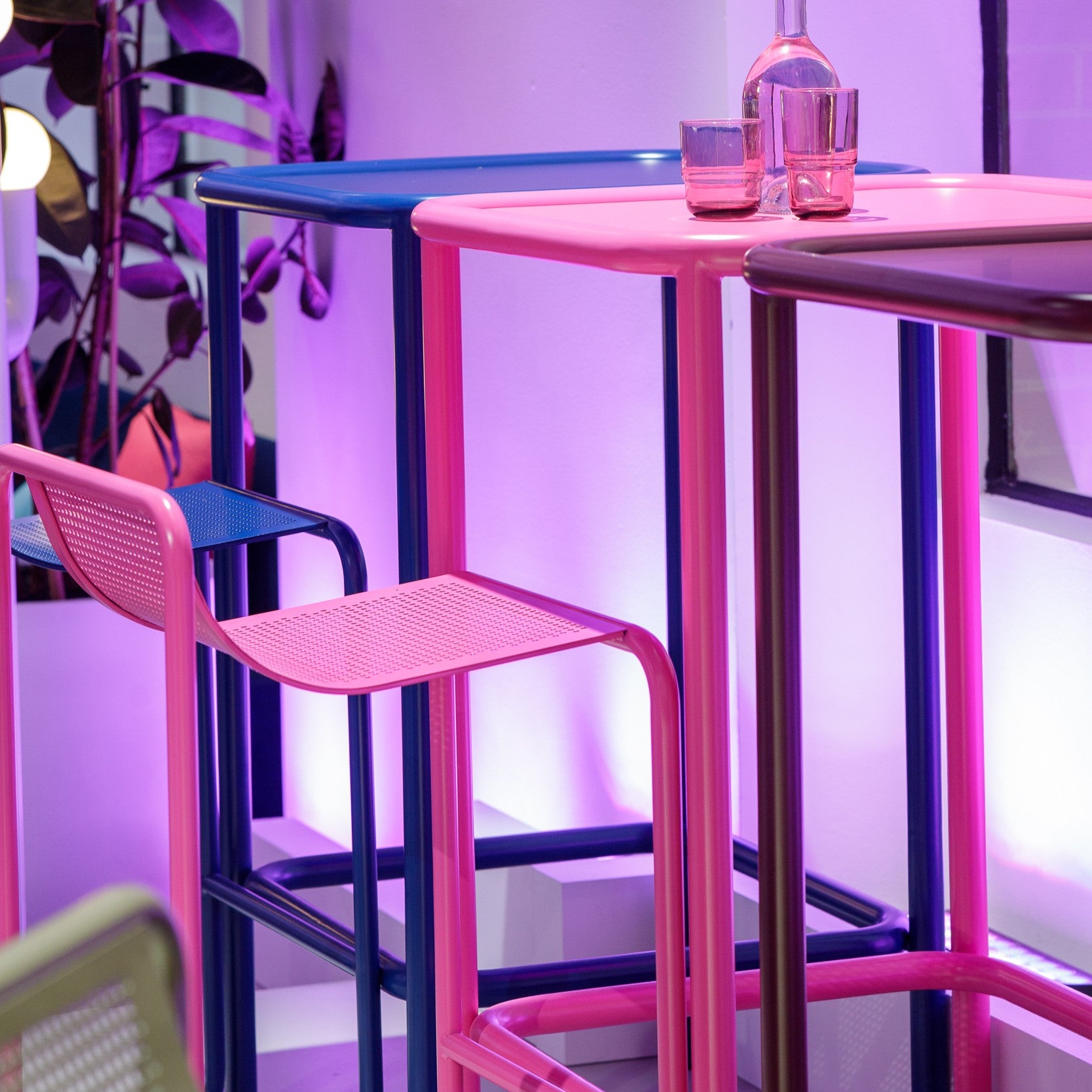 Colourful Isla bar stools and high tables in pink, blue and yellow arranged in a vibrant event setting