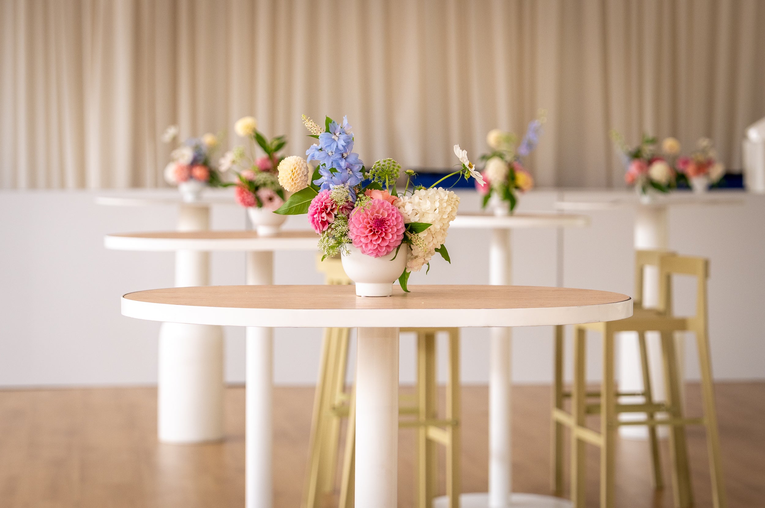 Tables with floral arrangements in a room with neutral decor