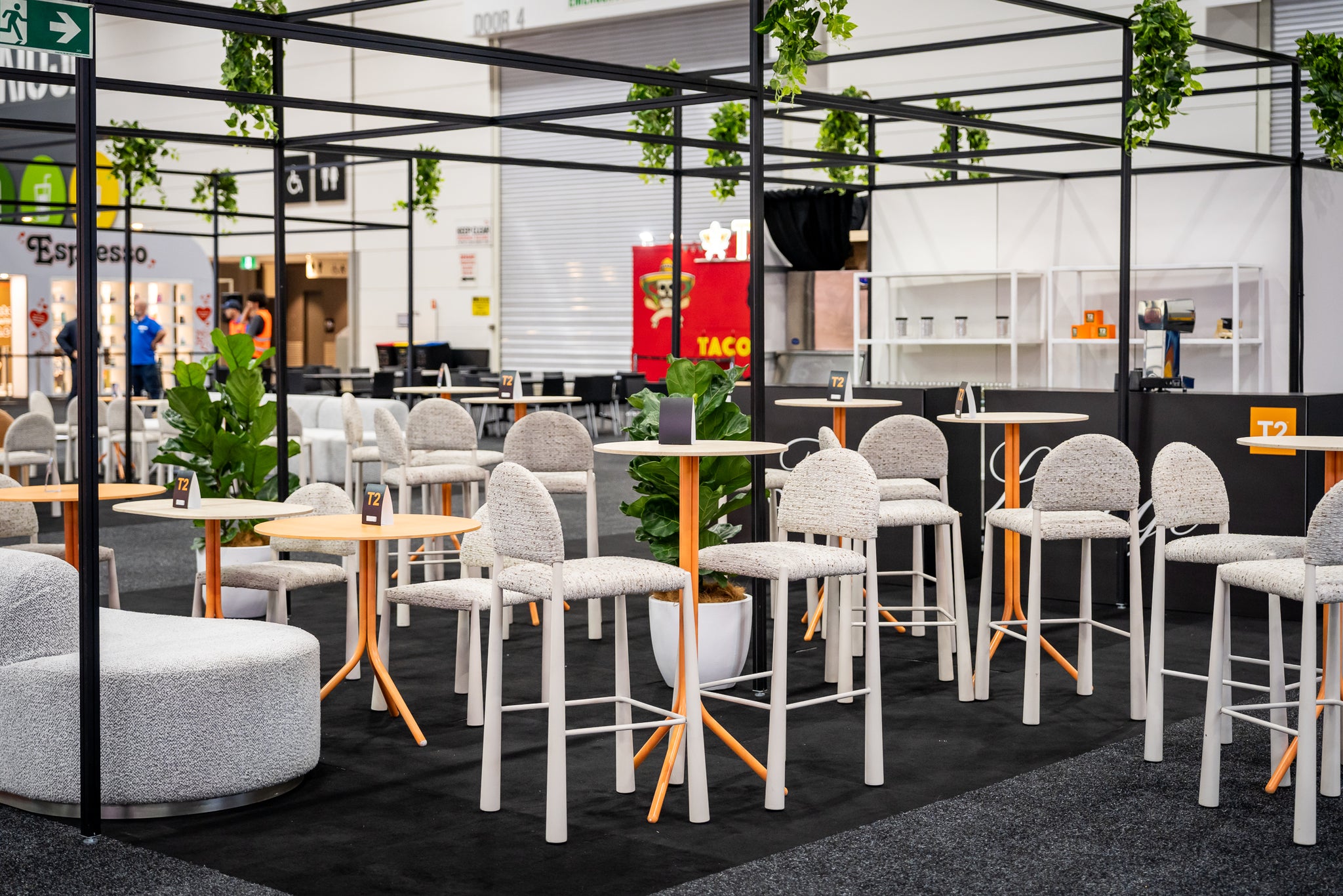 Expo seating area with white Pearl stools and orange tables.