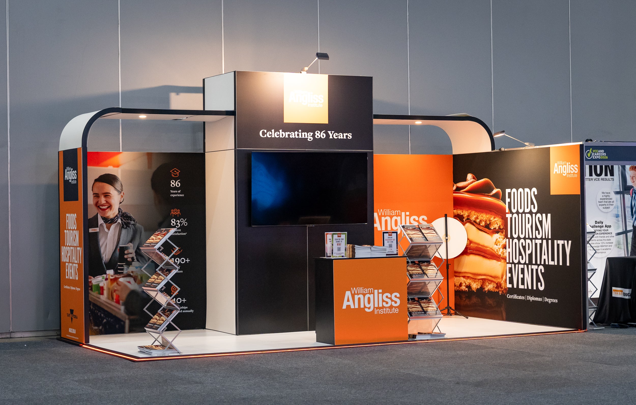 Exhibition stand with 'Angliss' branding featuring promotional materials and a screen.