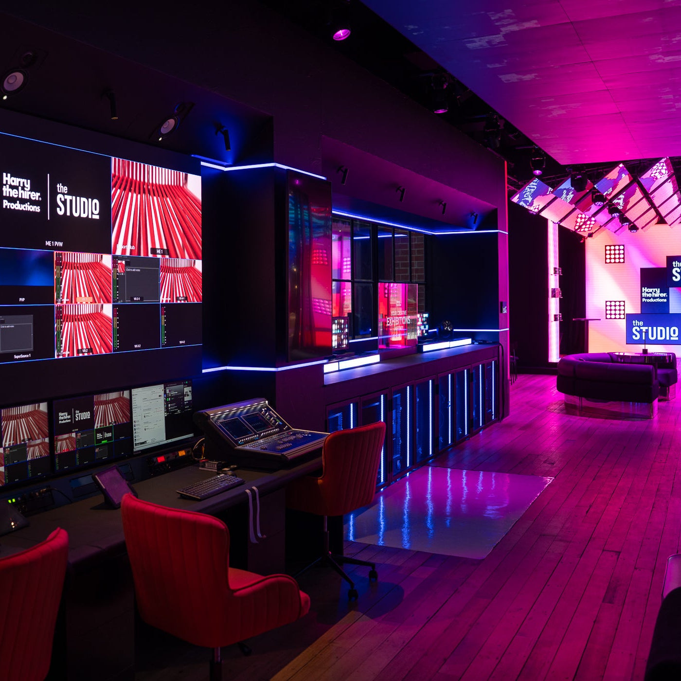 Control room with multiple monitors and a stage area in a studio setting.