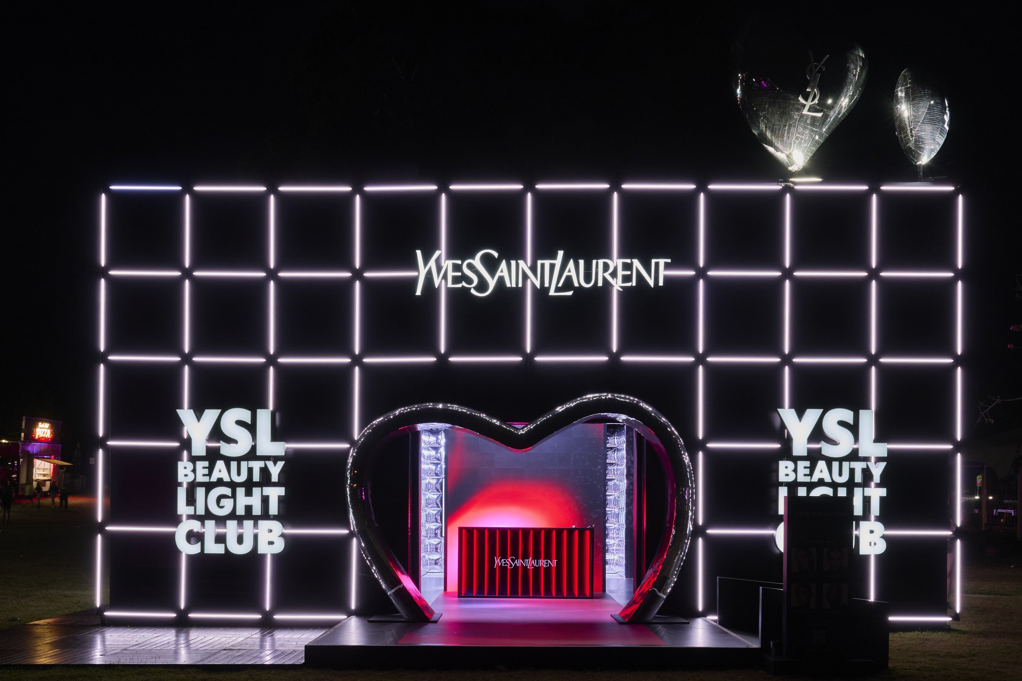 YSL Beauty Light Club pop-up activation display with illuminated wall and heart-shaped structure.