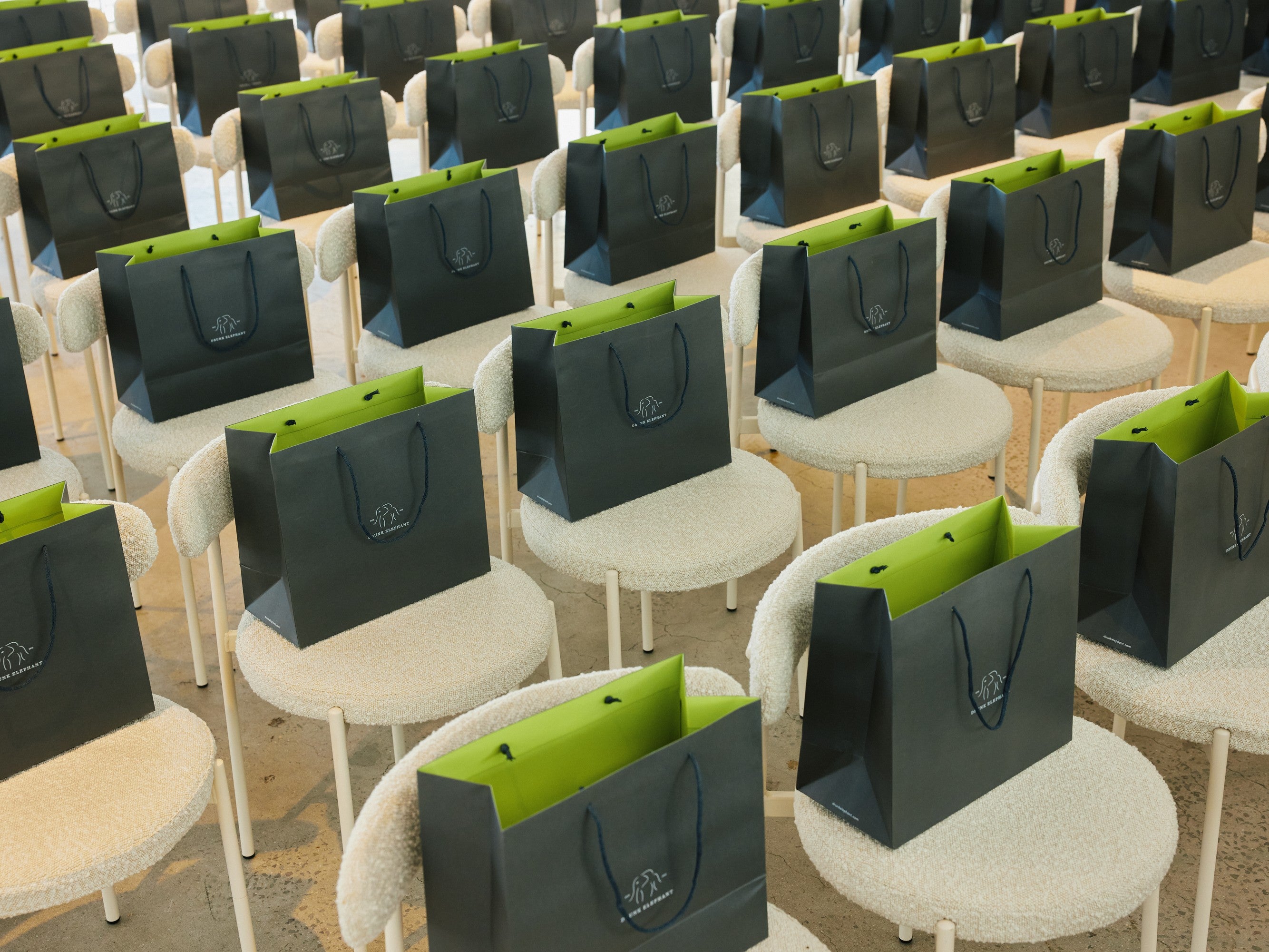 Black and green bags arranged on chairs in a room setting. Featuring our Margot Chair.