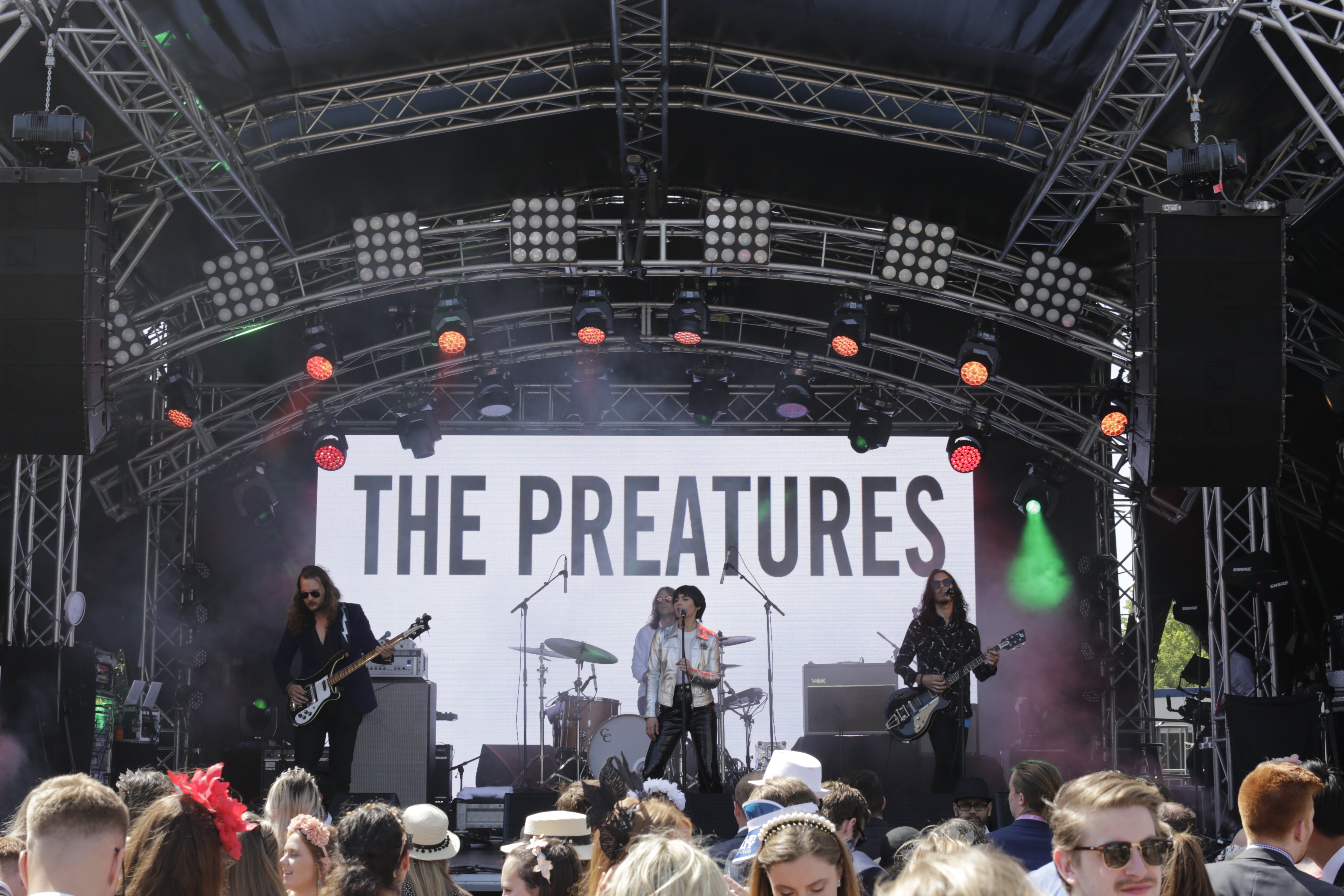 Band performing on stage with 'The Preatures' banner at a concert on a HTH Productions-built stage