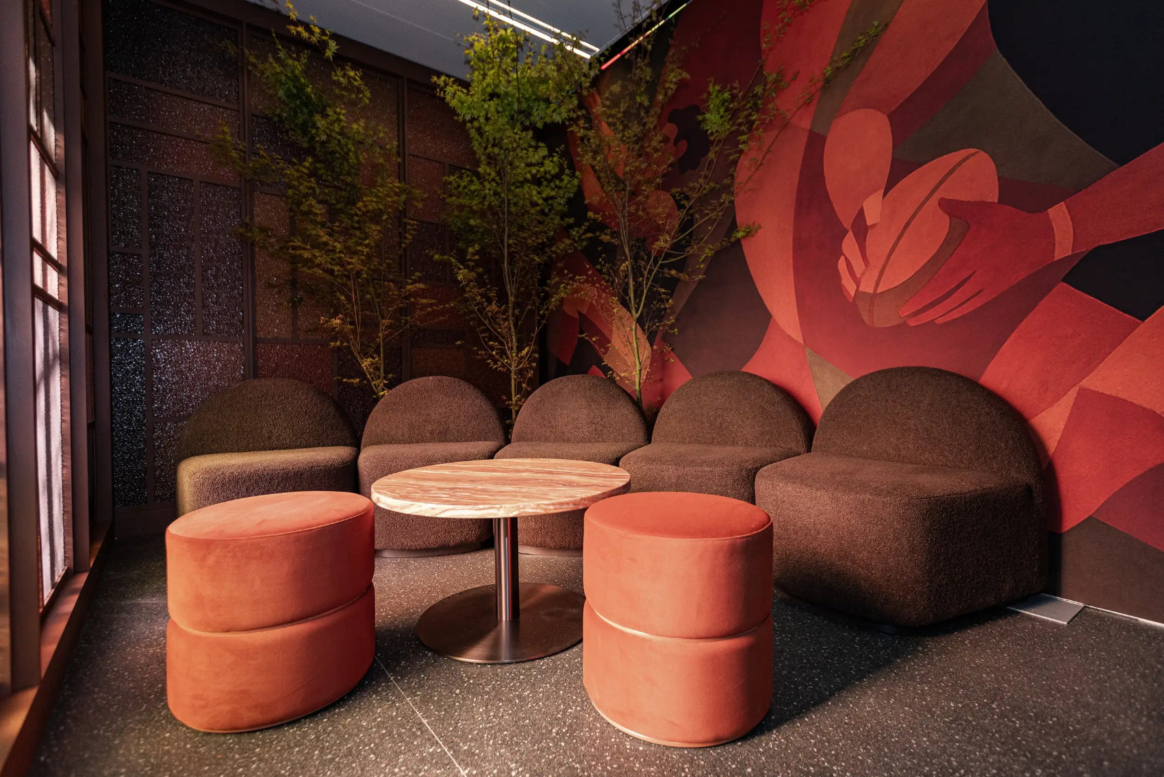 Modern interior with brown and red furniture and a decorative wall.