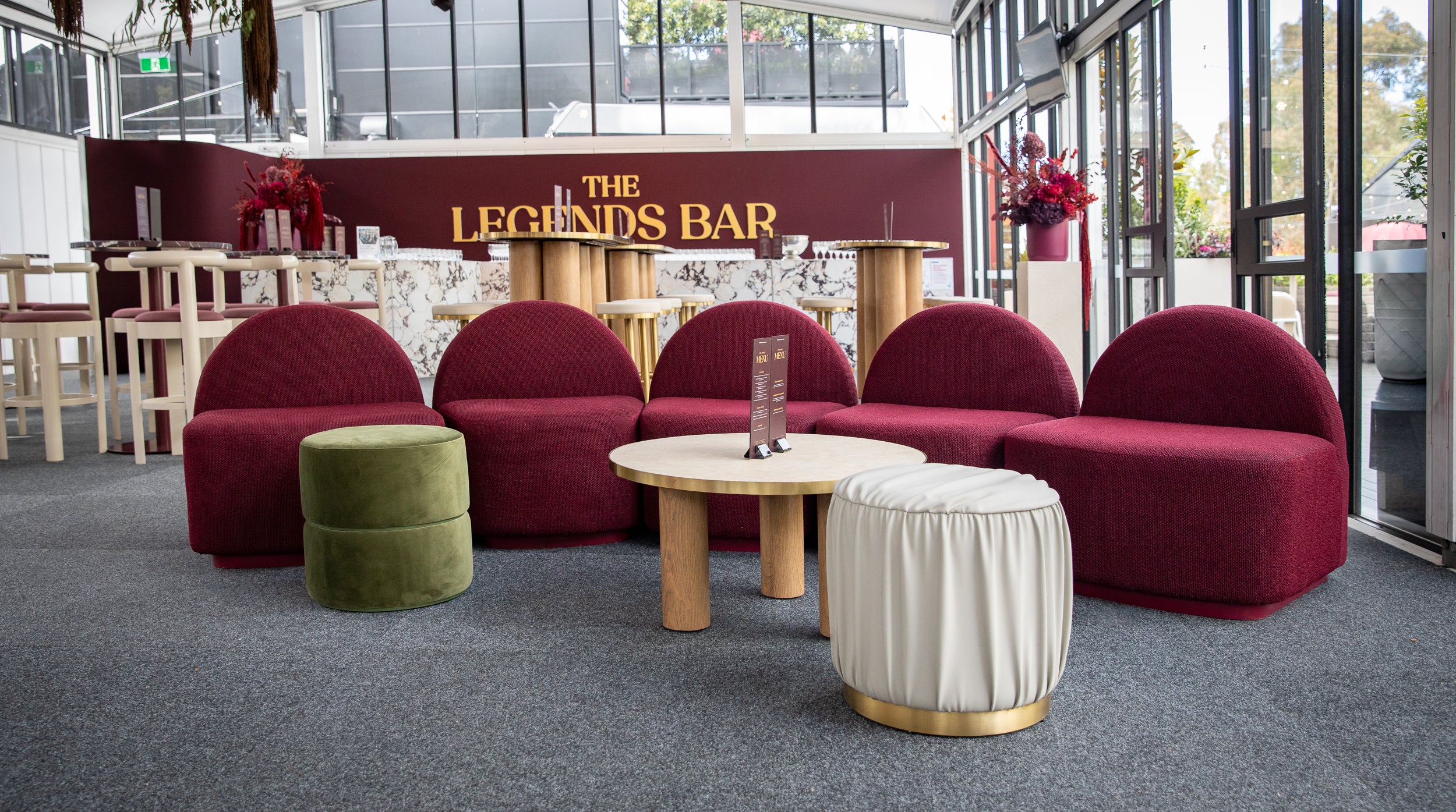 Red Harper sofa set in a bar area with 'The Legends Bar' sign. 