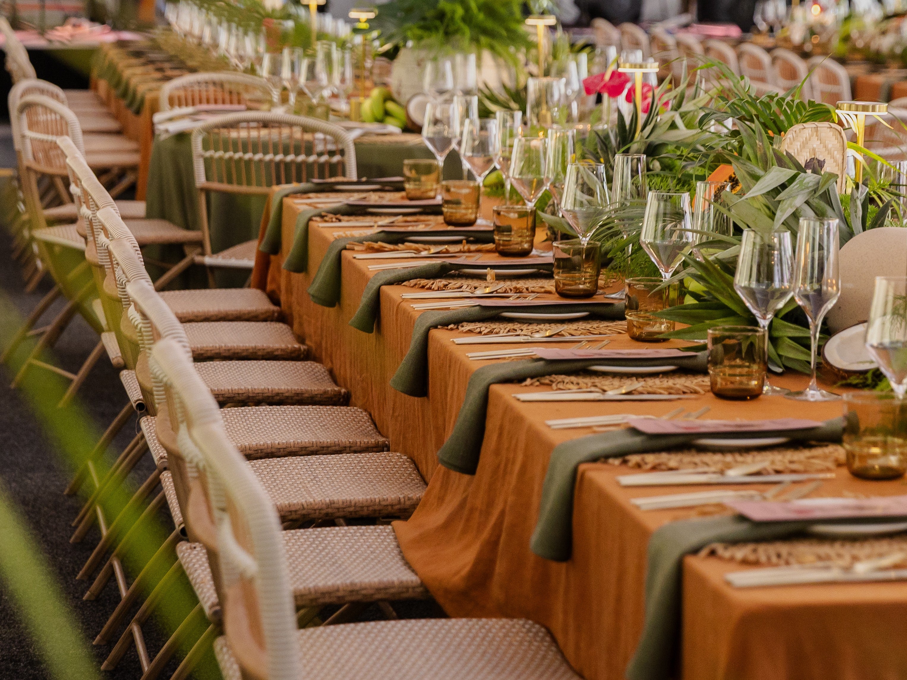 Decorated tables with green tablecloths and floral arrangements at a private birthday dinner