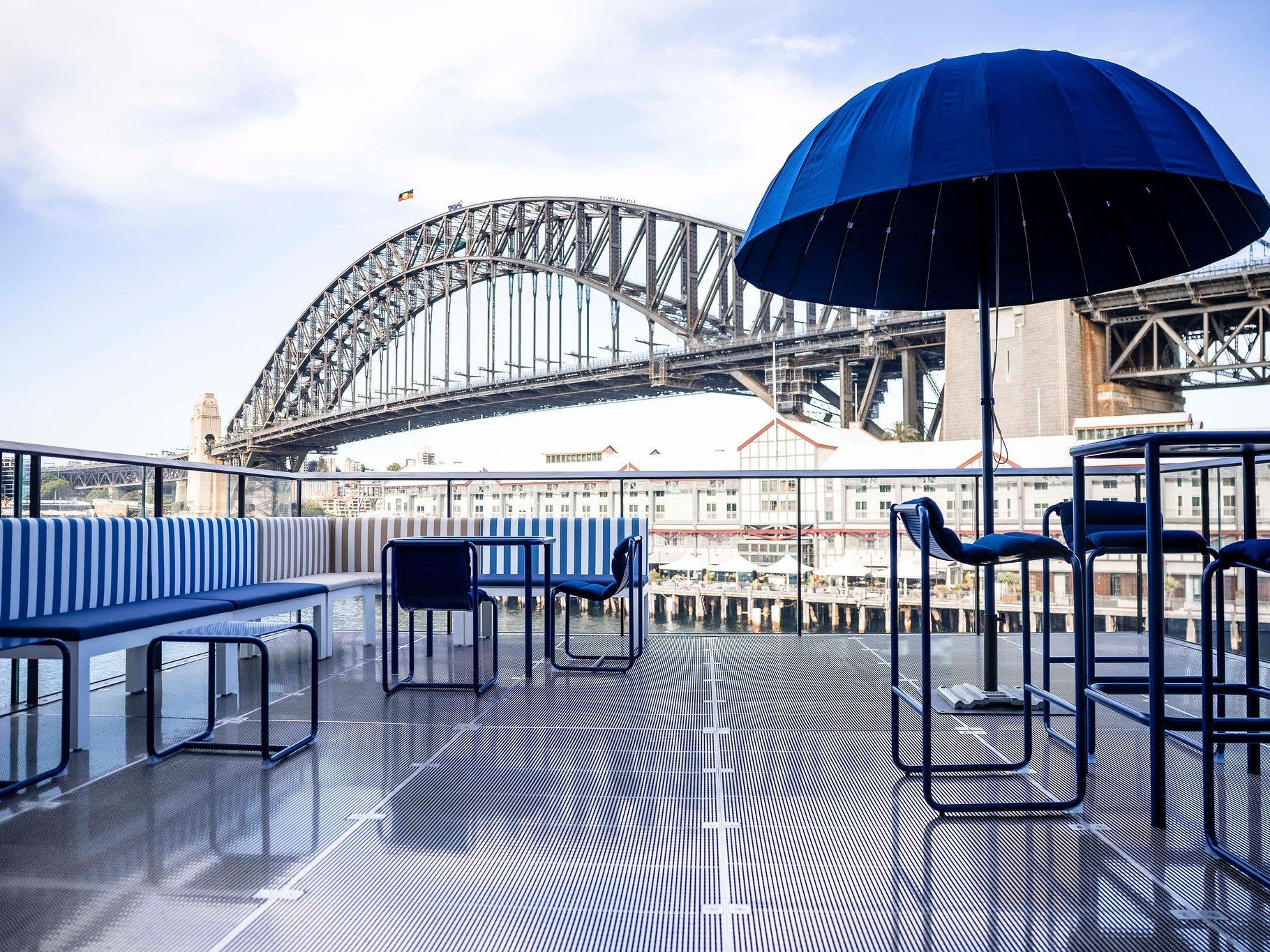 Waterfront event terrace with navy blue seating and bar stools with views of the Sydney Harbour Bridge